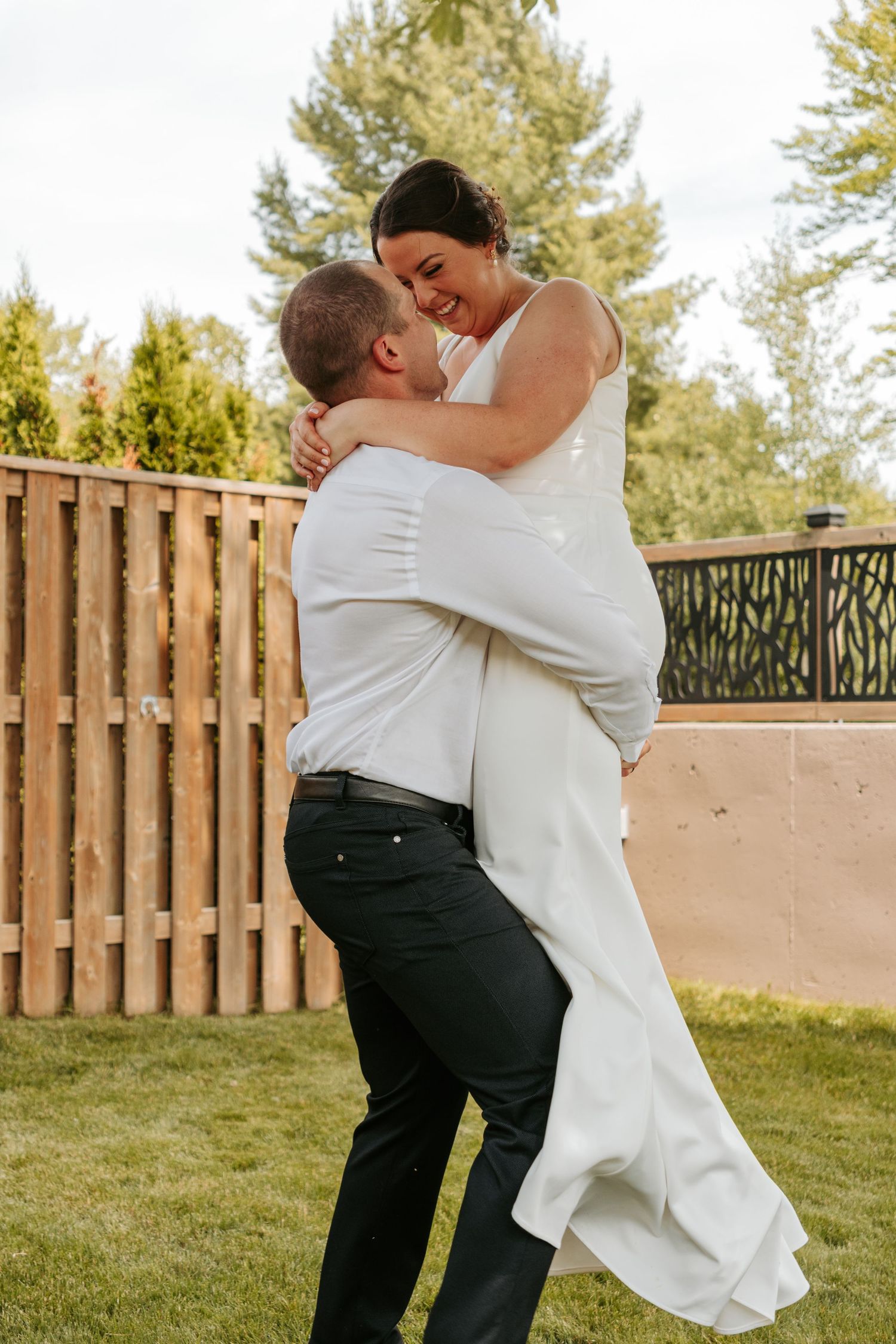 A couple shares a romantic moment during their wedding photoshoot in an outdoor garden setting.
