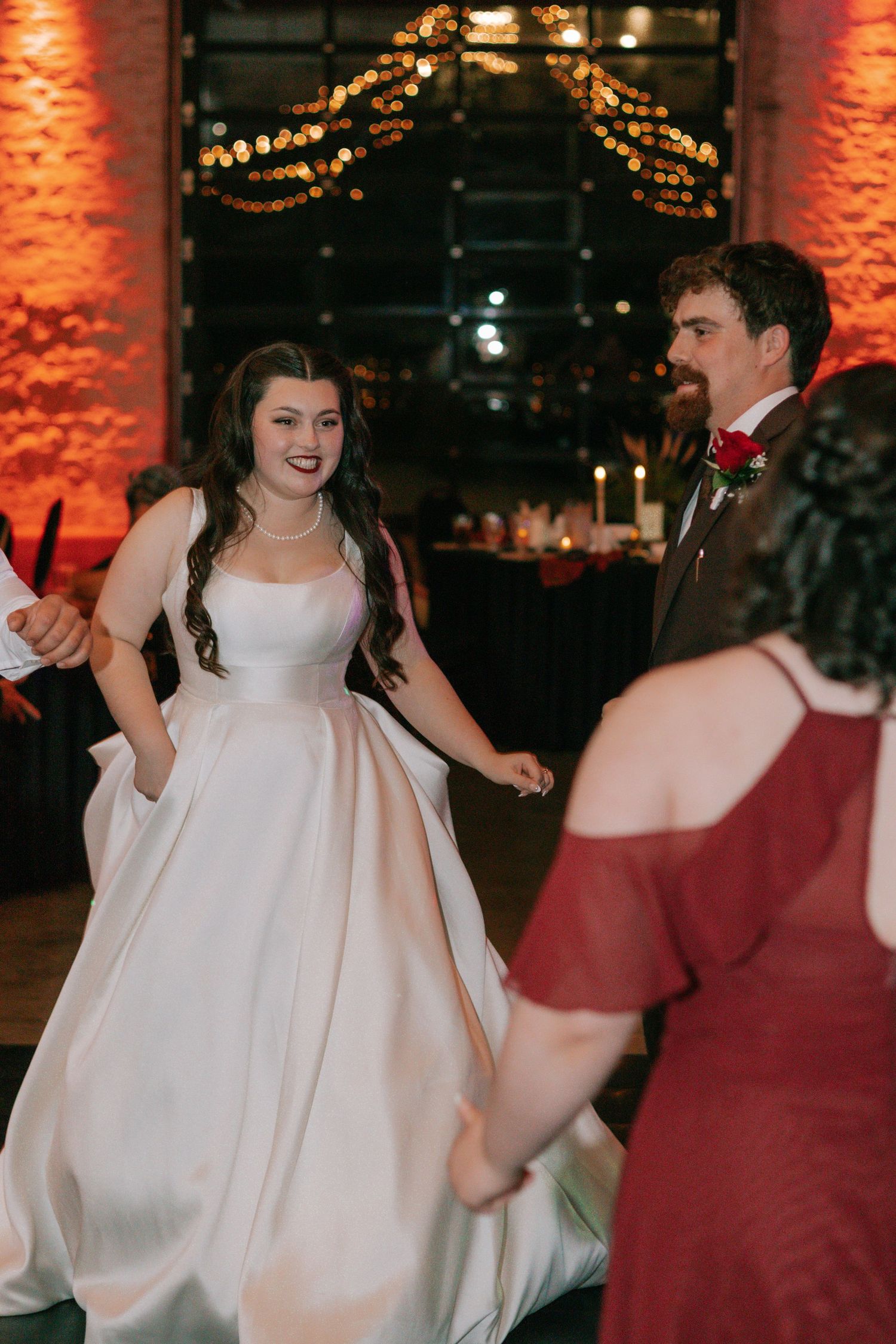 A bride in a beautiful white ballgown dances joyfully at her wedding reception.