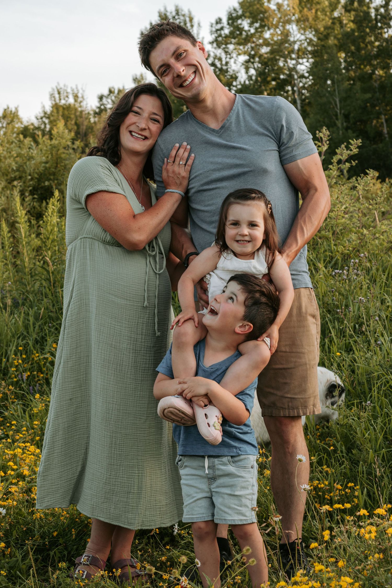 Candid family moment captured in a meadow with yellow flowers.