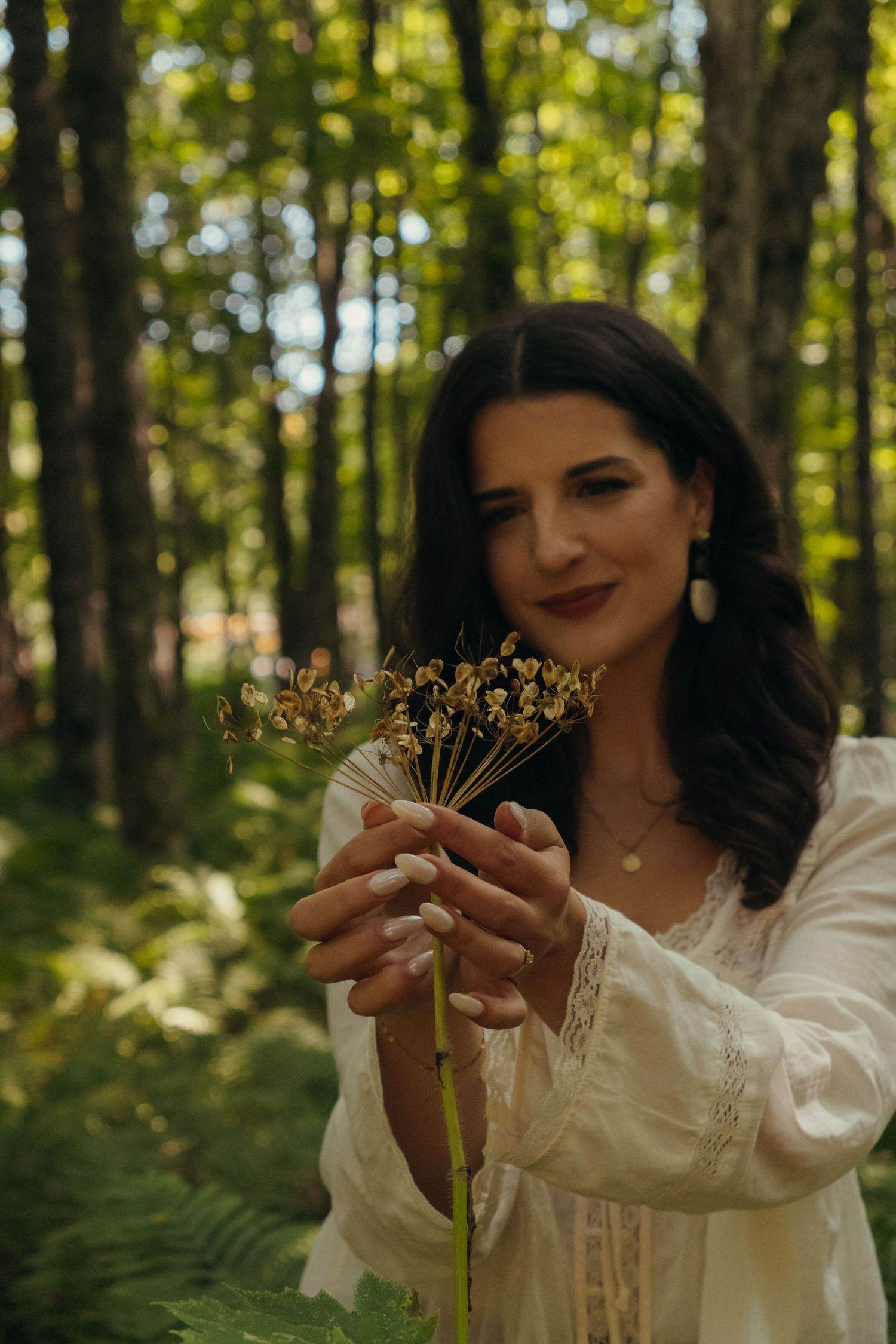 Whimsical forest portrait with dried flowers and natural scenery.