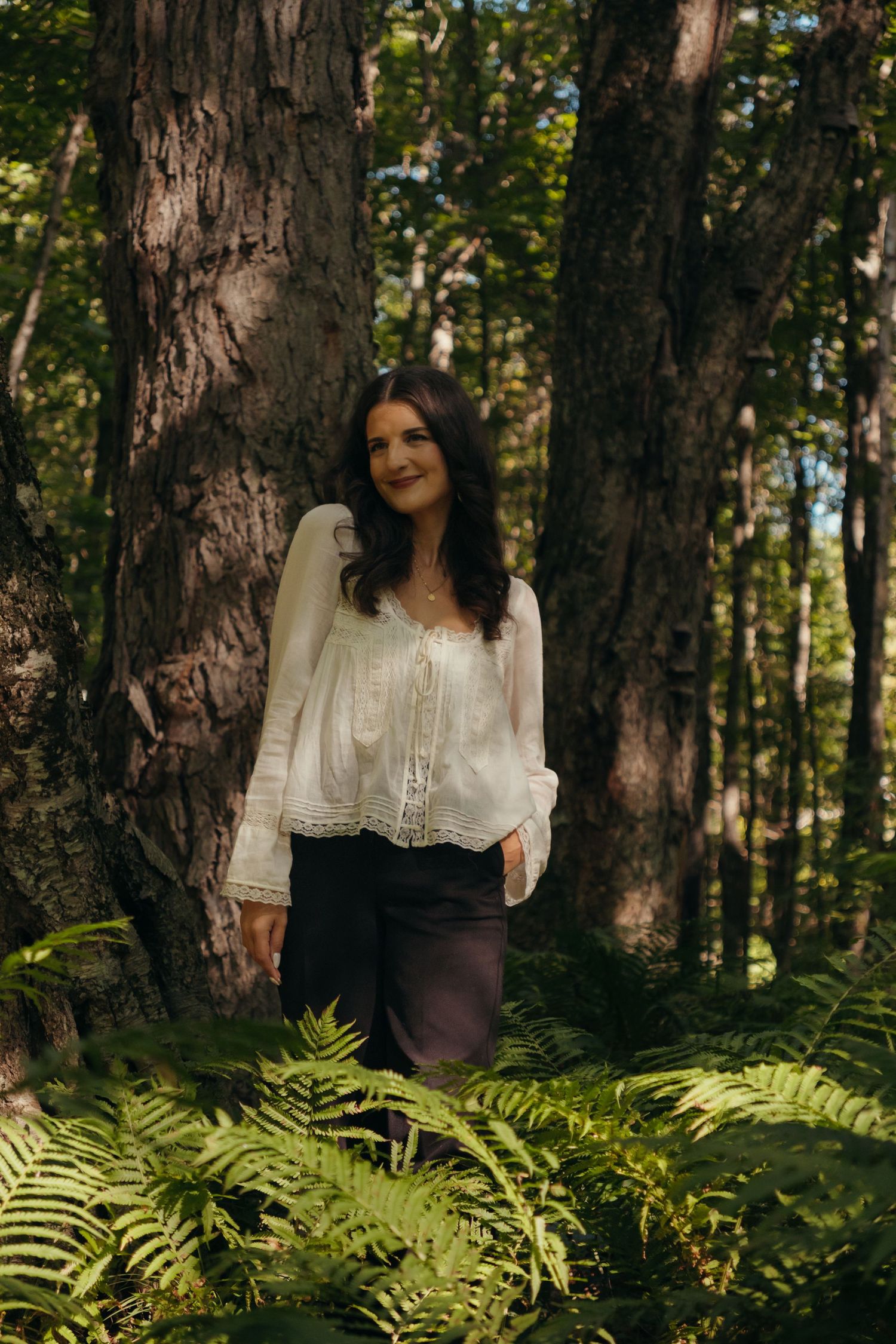 Romantic forest photography featuring white vintage blouse and natural greenery.