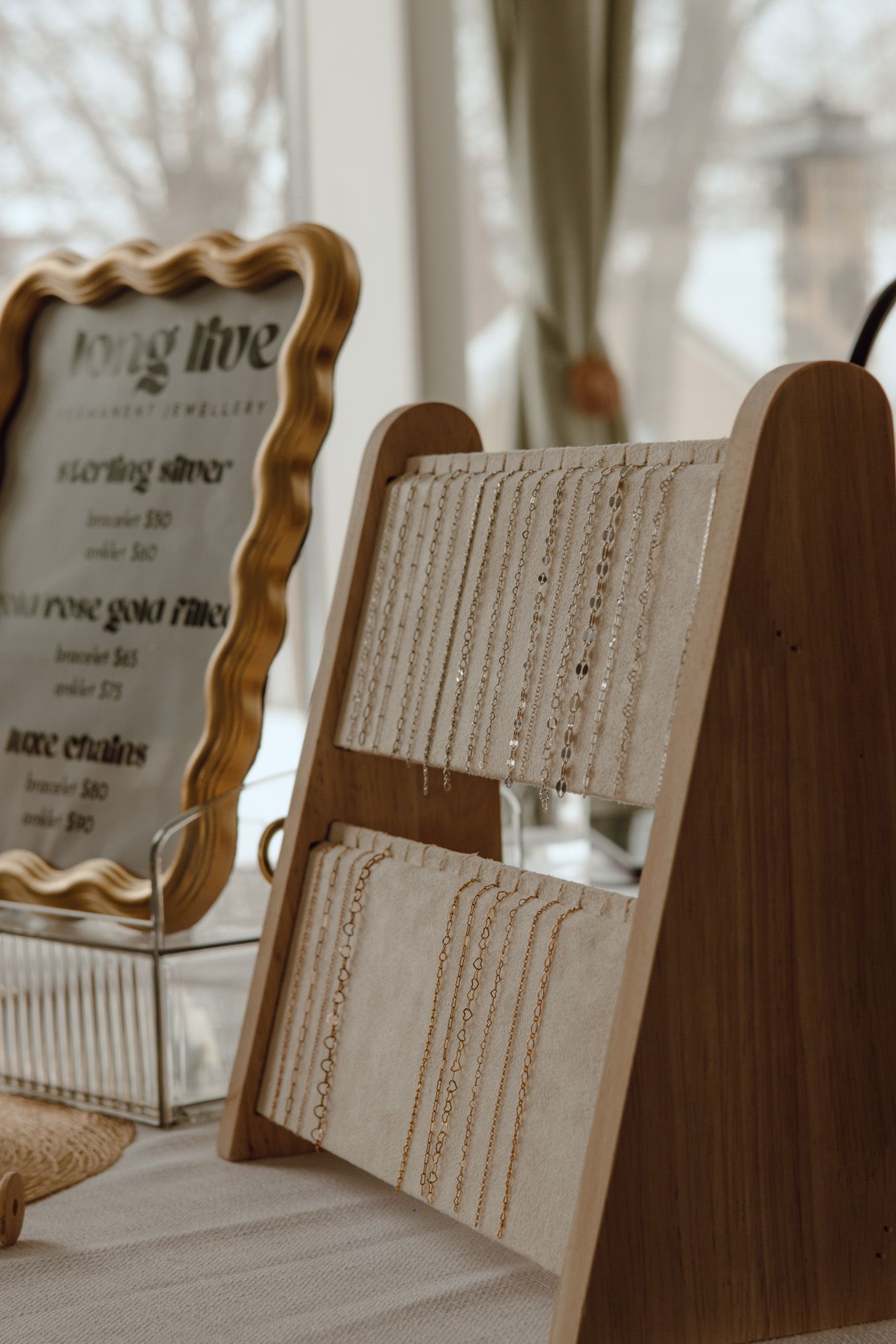 Wooden display stands holding jewelry chains in an elegant retail setting.