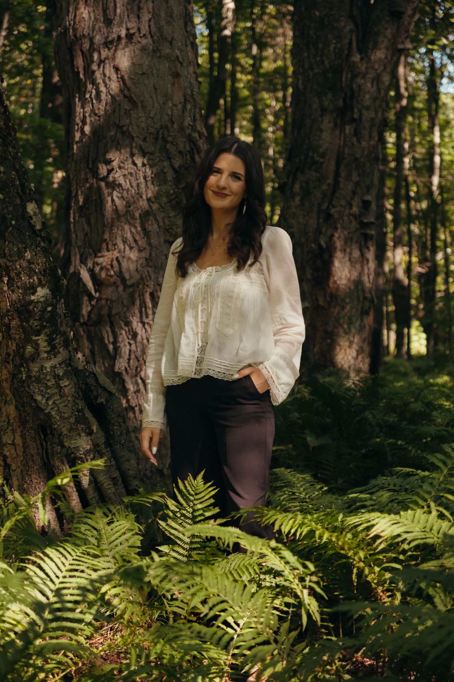 Ethereal forest photography featuring white lace blouse among ferns and trees.