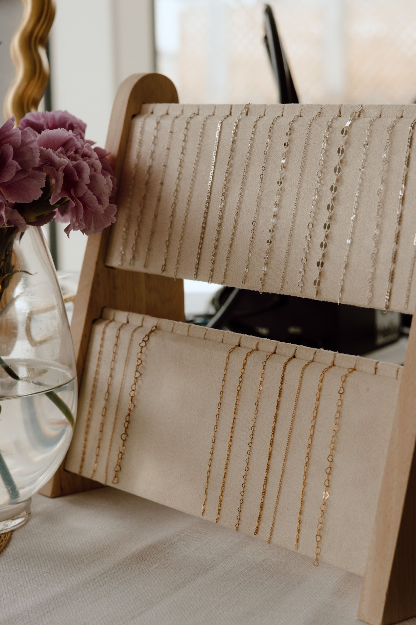 Display board showcasing multiple gold and silver chains arranged in neat vertical rows.