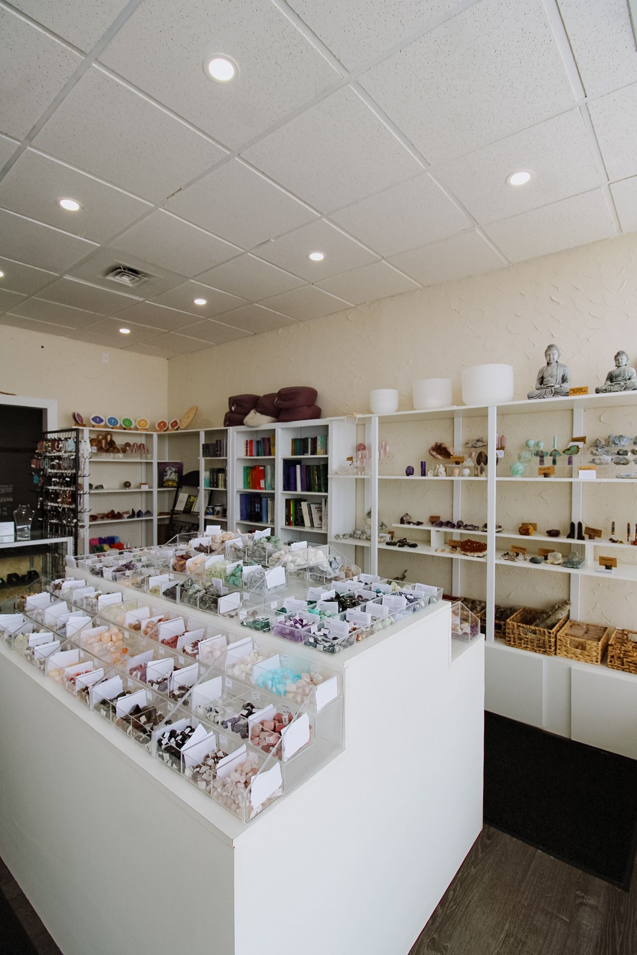 Clean modern retail space with white display counters showcasing crystal and mineral specimens.