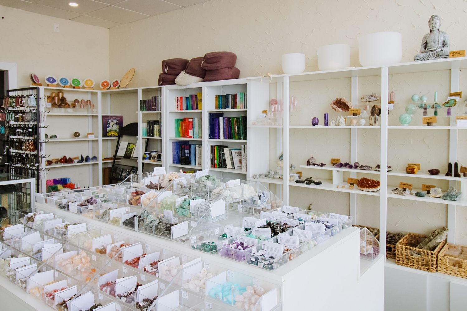 Panoramic view of a bright retail space with white shelving and crystal displays.