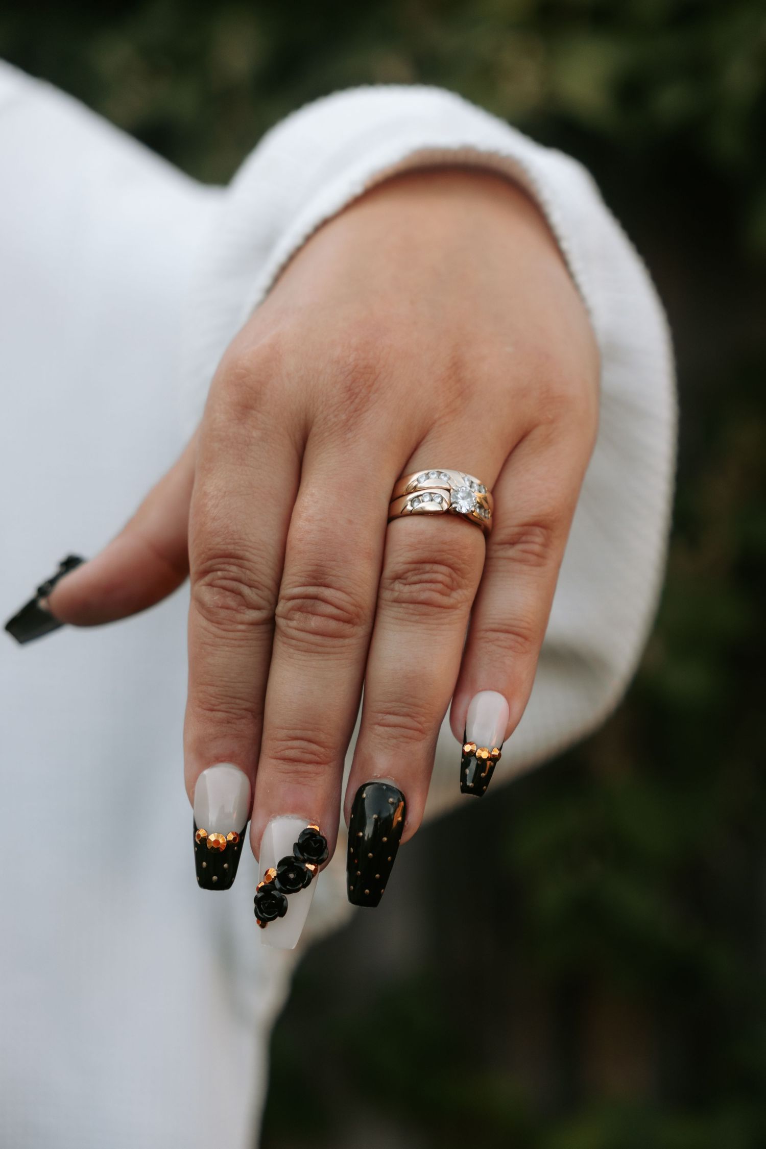 Close-up of hands showing off black and silver nail art and an engagement ring.