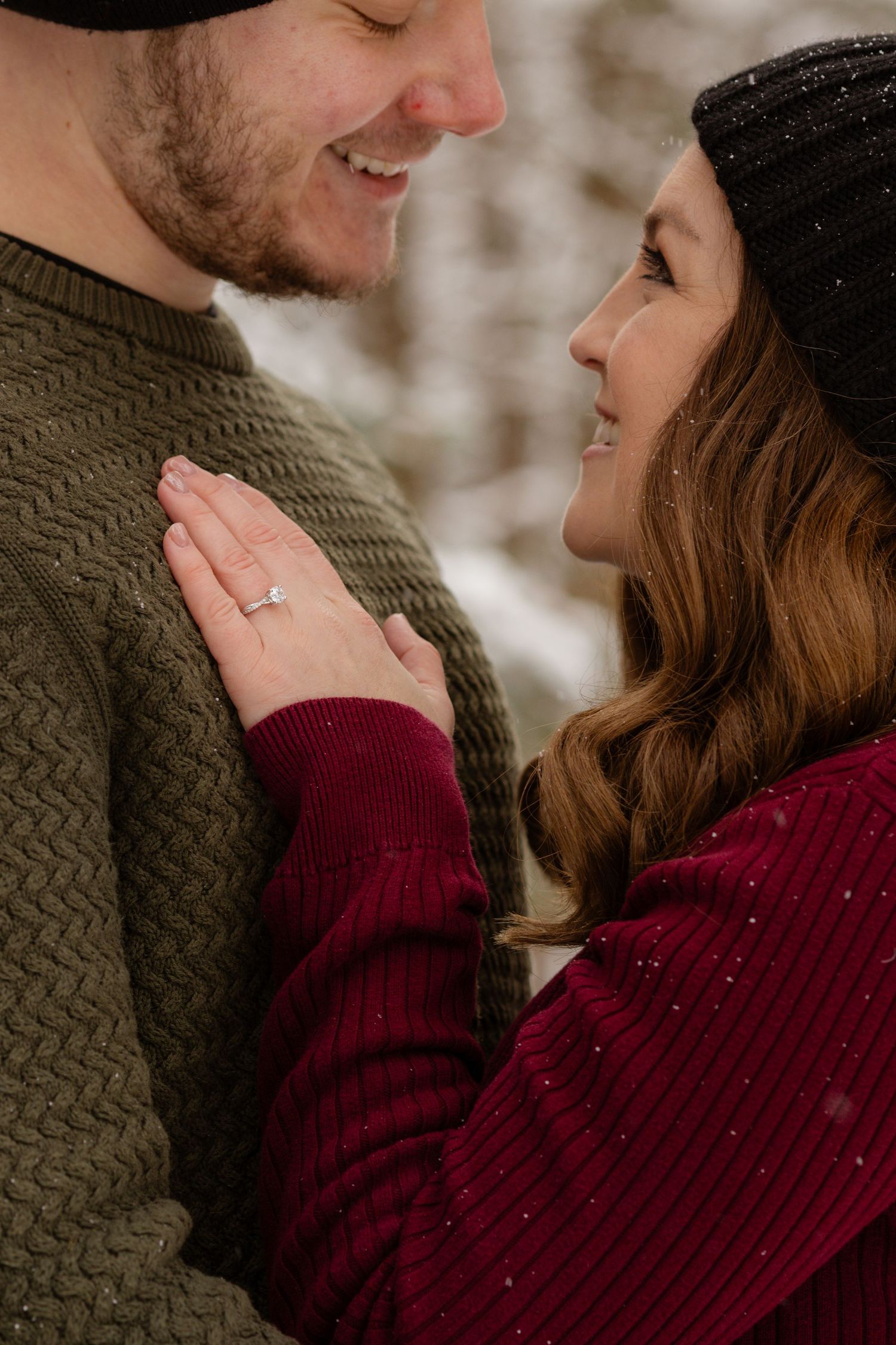 Intimate winter engagement portrait of a couple in knit sweaters sharing a tender moment.