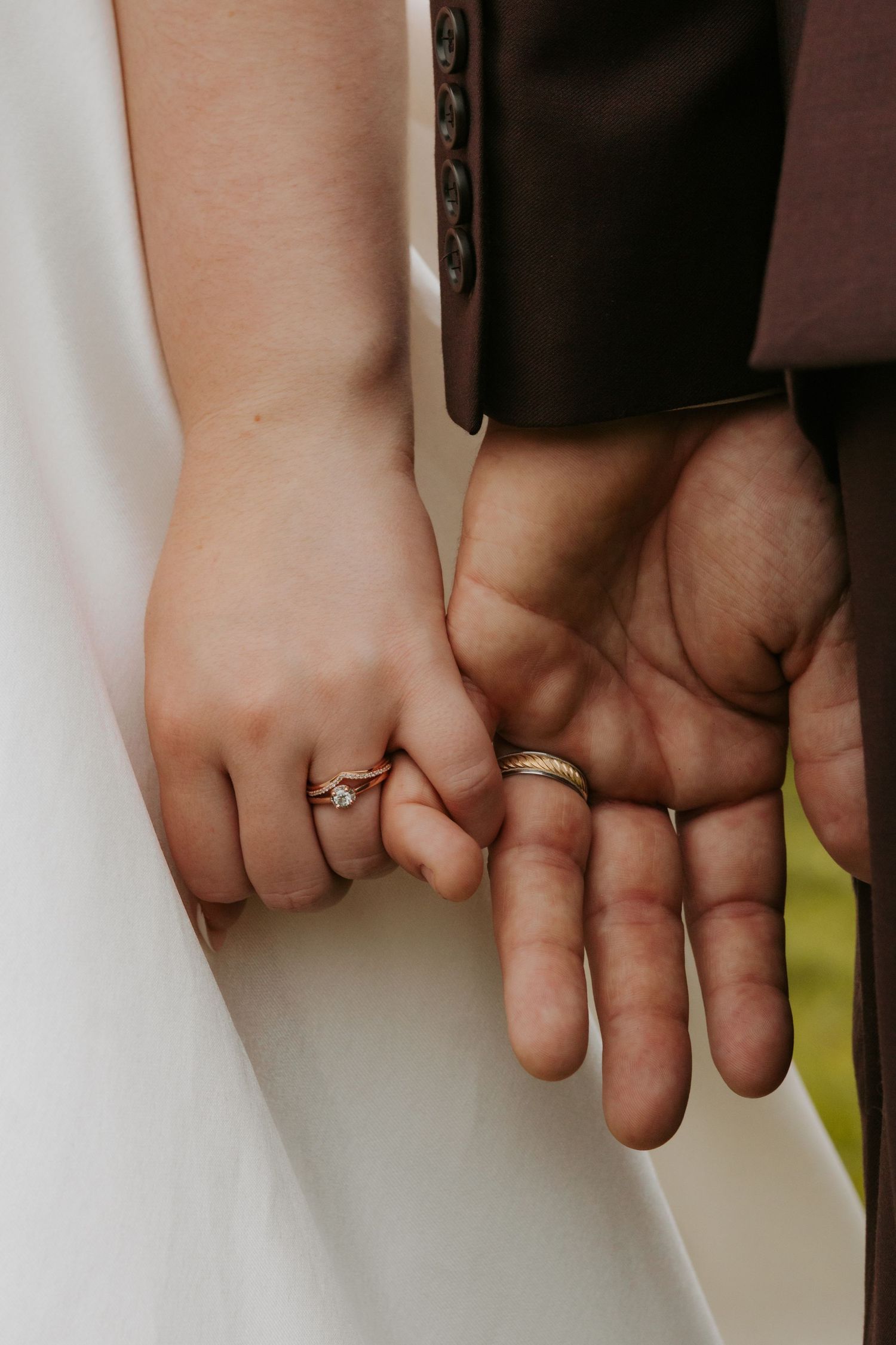 Close-up of newlyweds' hands showing their wedding rings.