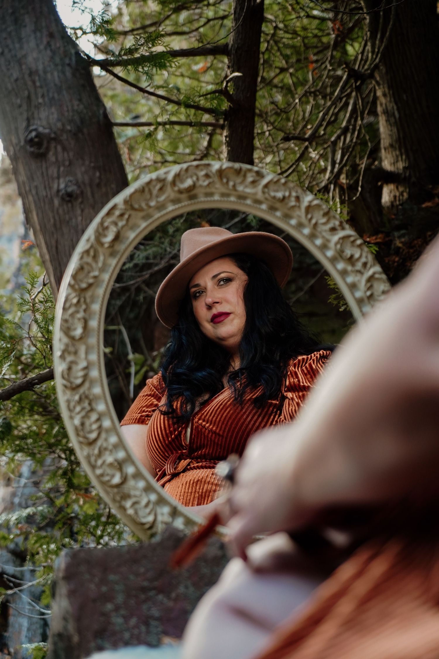 Vintage mirror nestled among tree branches creating artistic reflections.