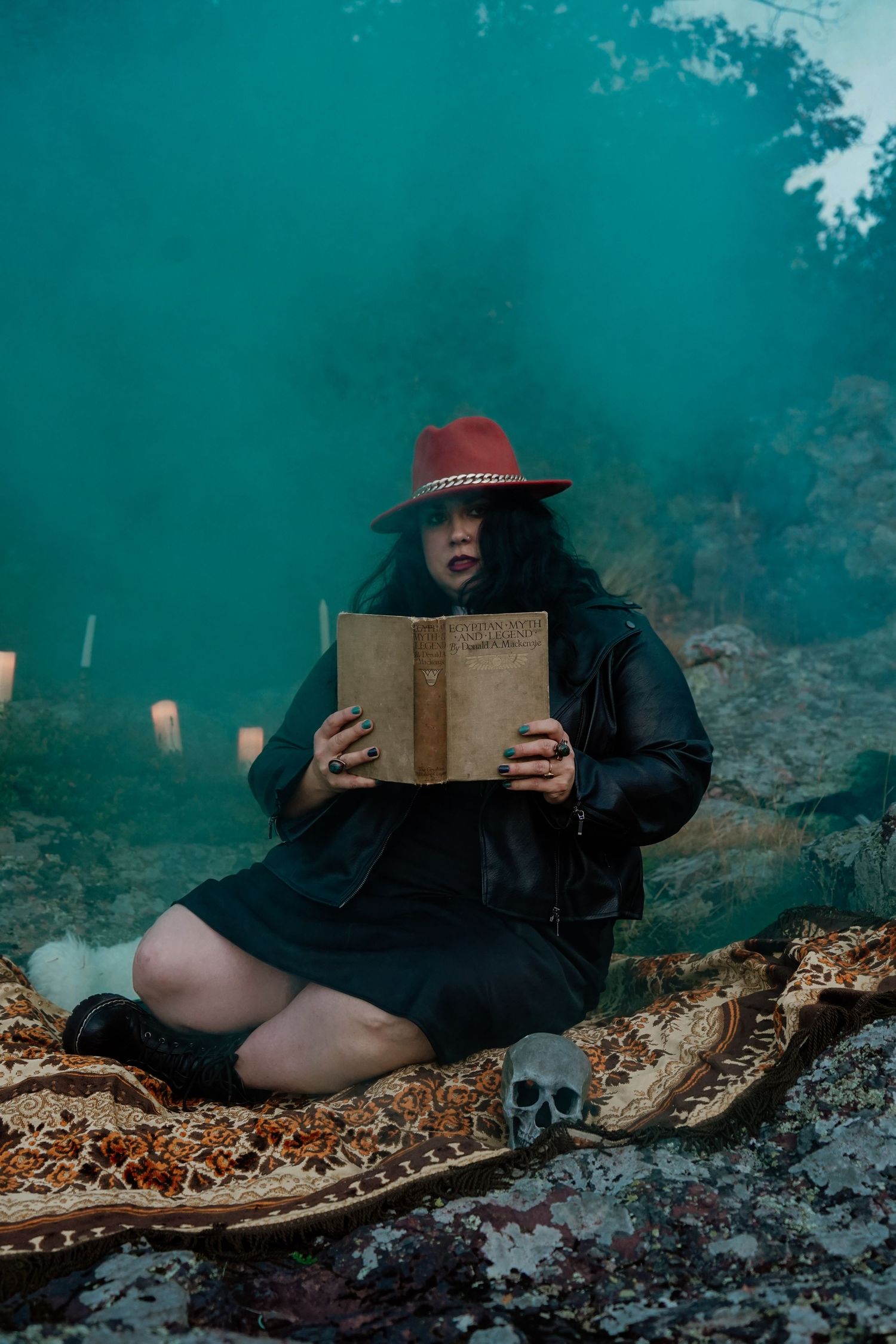 Mysterious reading scene with person in red hat against turquoise backdrop.