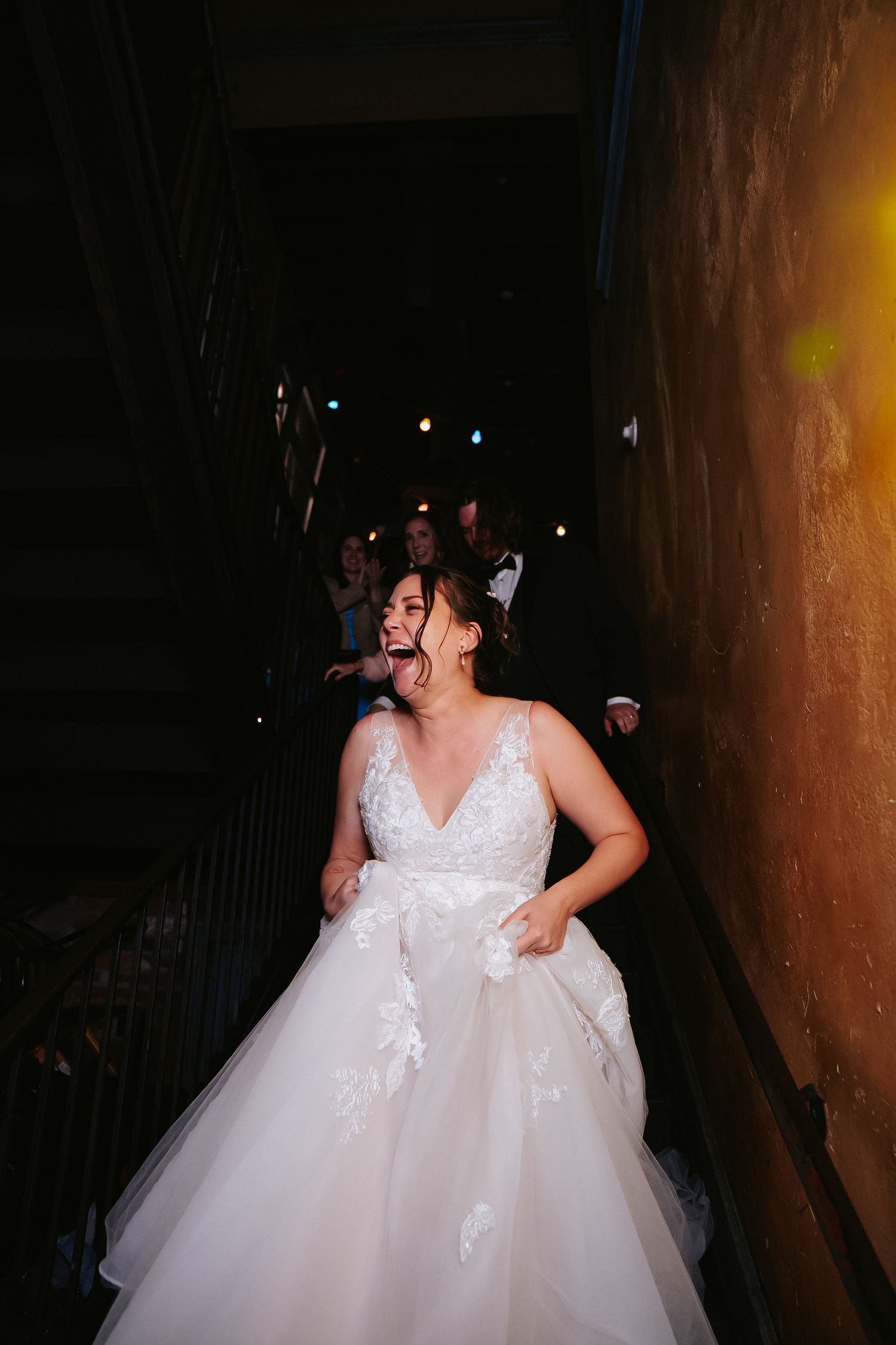 Richmond Virginia bride exclaims at the bottom of a staircase after going through a human tunnel of her guests at Havana 59 restaurant