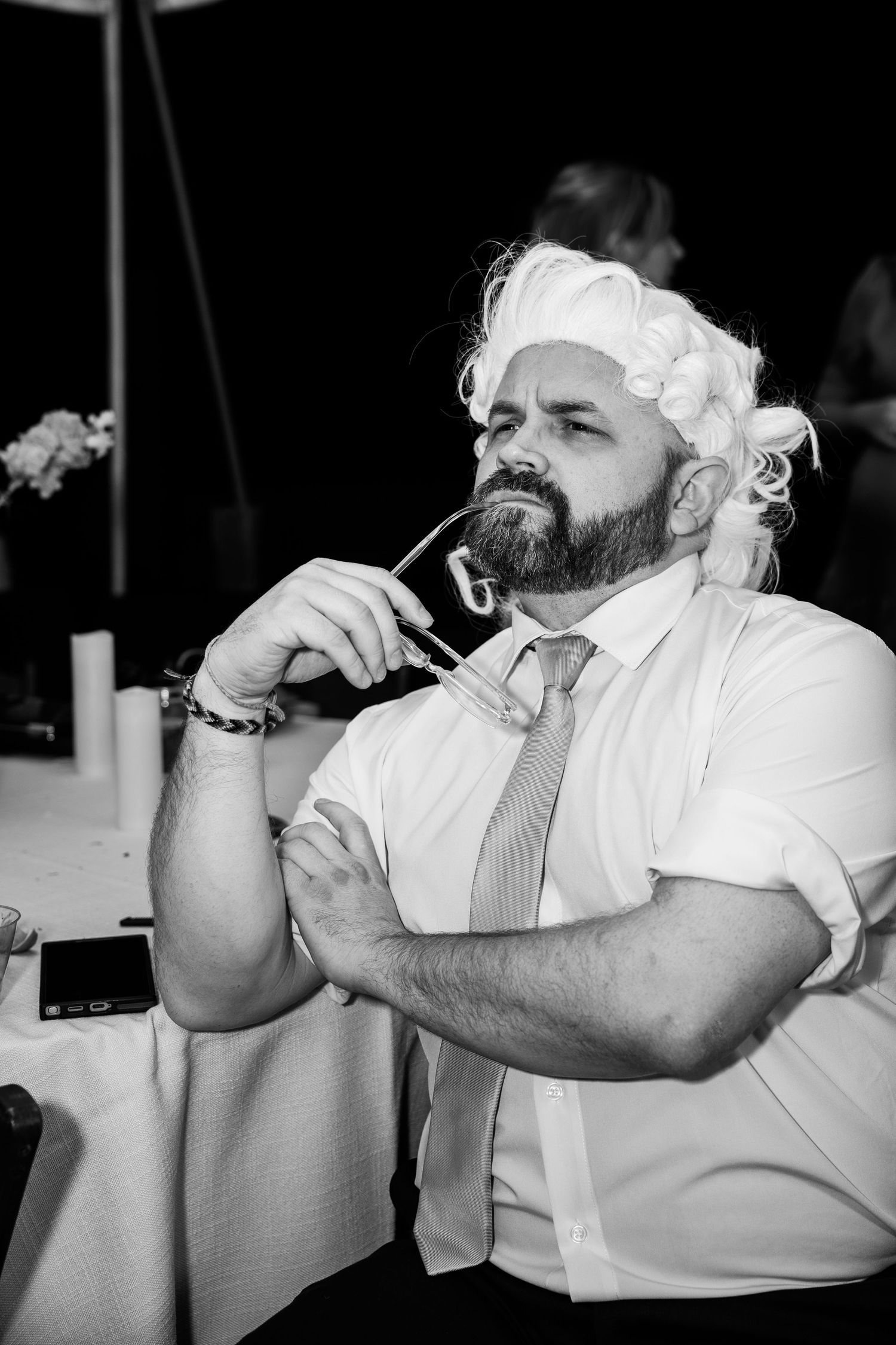 Wedding guest in colonial wig chews on his glasses and stares at his partner on the dancefloor in  Church Hill, Richmond Virginia