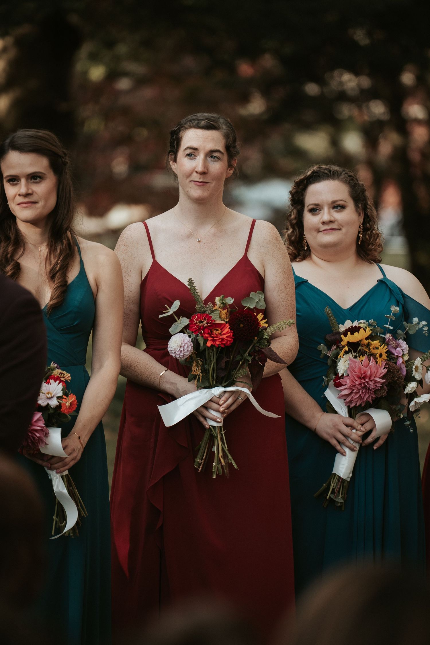 Bridesmaids look on as their friend is married during a queer wedding ceremony at Byrd Park in Richmond Virginia