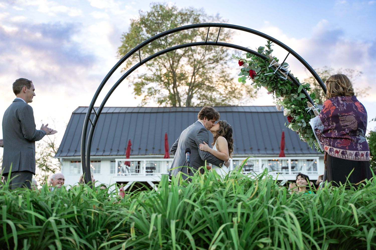 A Bride and Groom share their ceremonial kiss under dramatic purple and pink skies of Northern Virginia