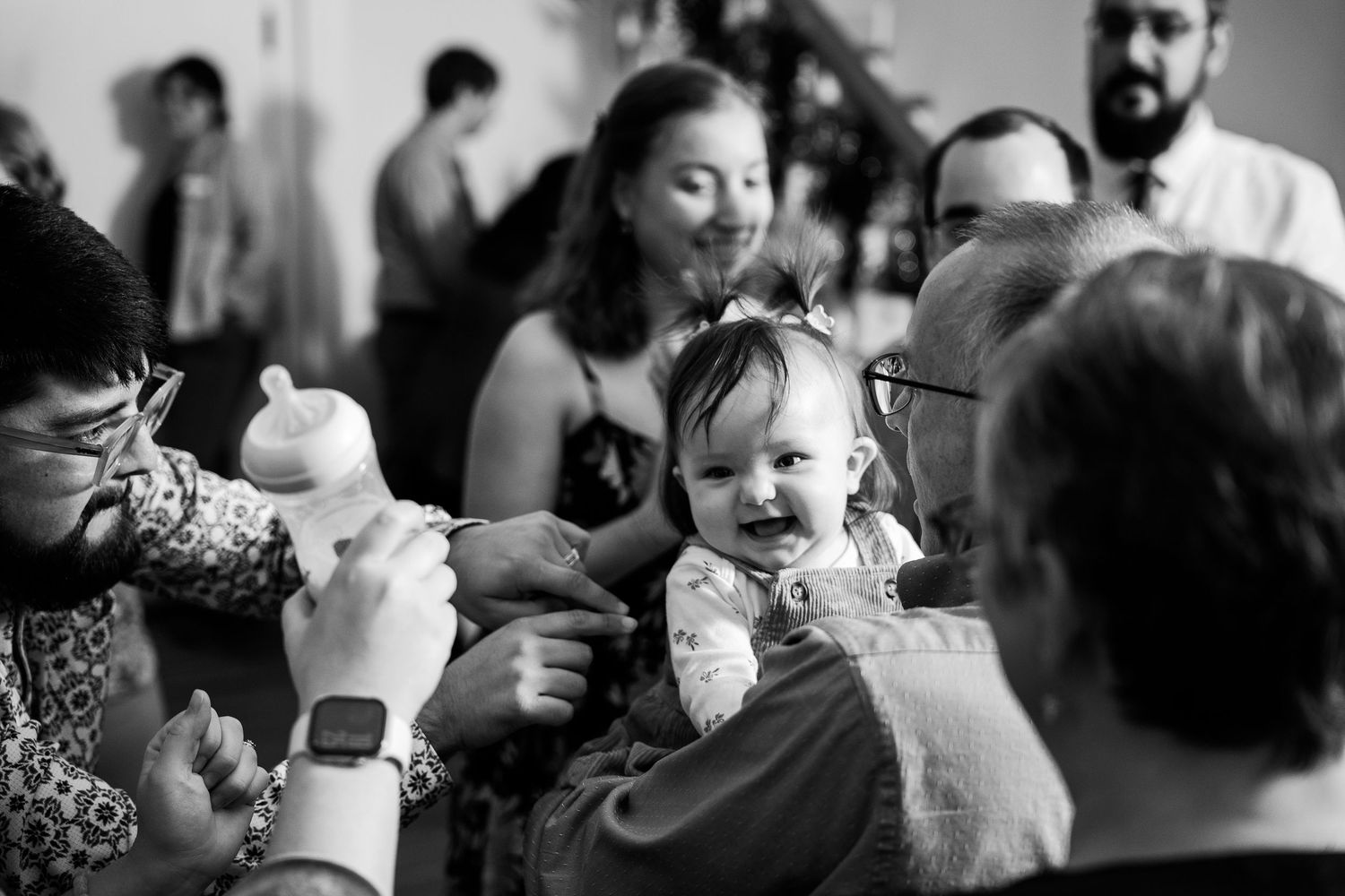 Baby smiles on the shoulder of a family member during a gay wedding reception in Shenandoah Virginia