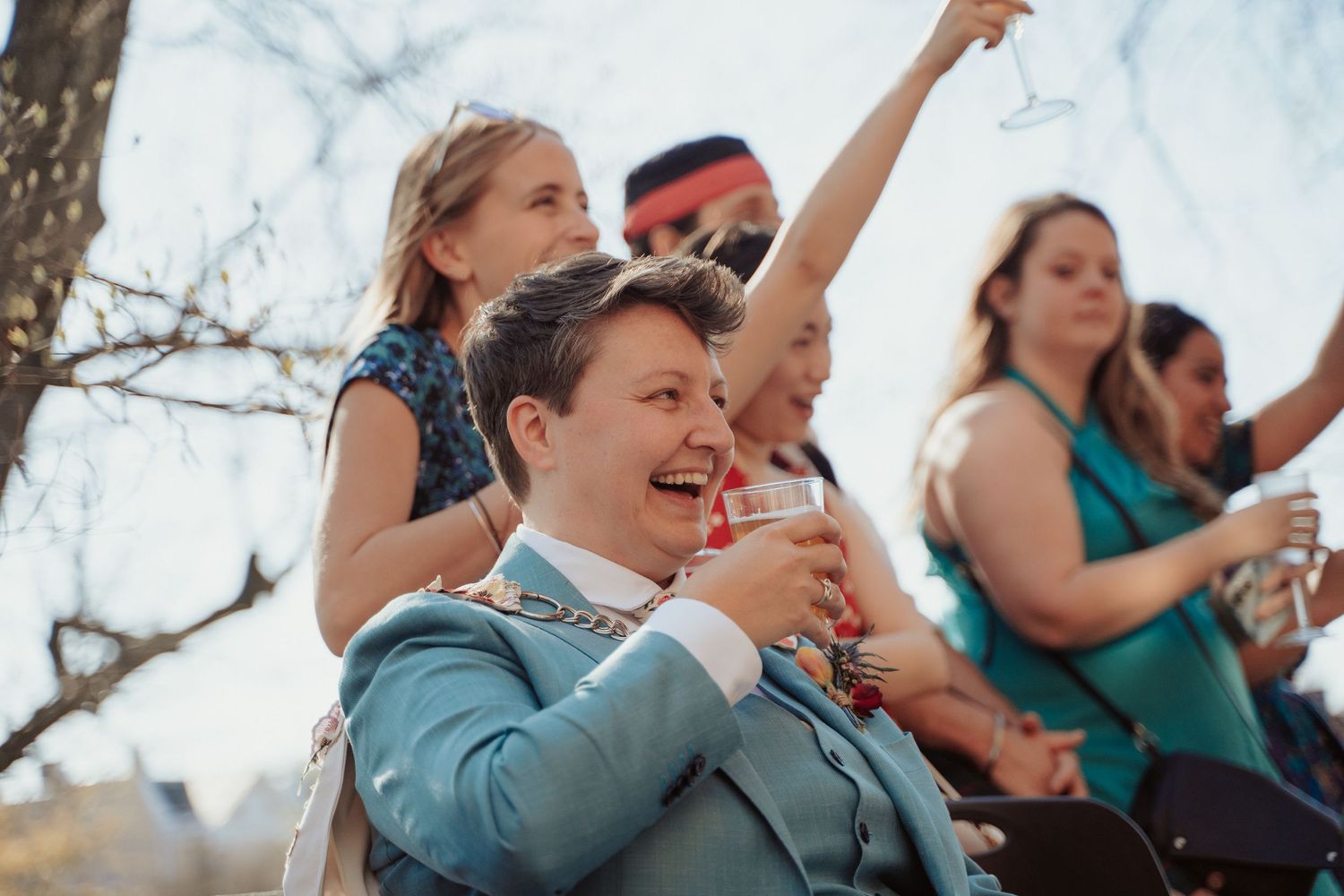 Queer bride laughs during the performance of her friends during their cocktail hour at the Branch Museum in Richmond Virginia