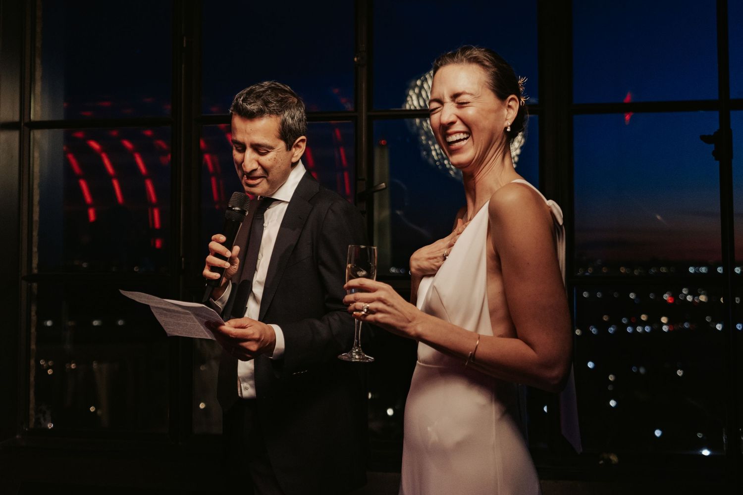 Hotel Washington newlyweds address their guests while the Washington DC skyline glows behind them