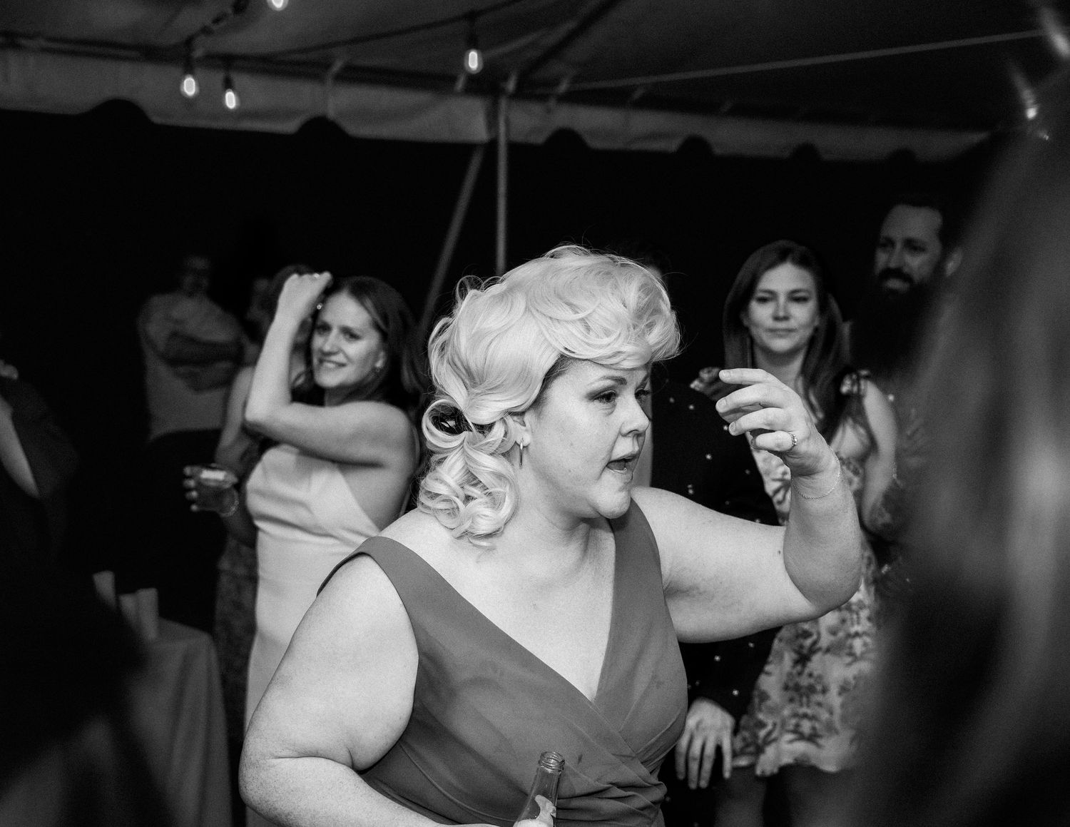 Bridesmaid in dress and colonial wig moves through the dancefloor of a Richmond Virginia wedding