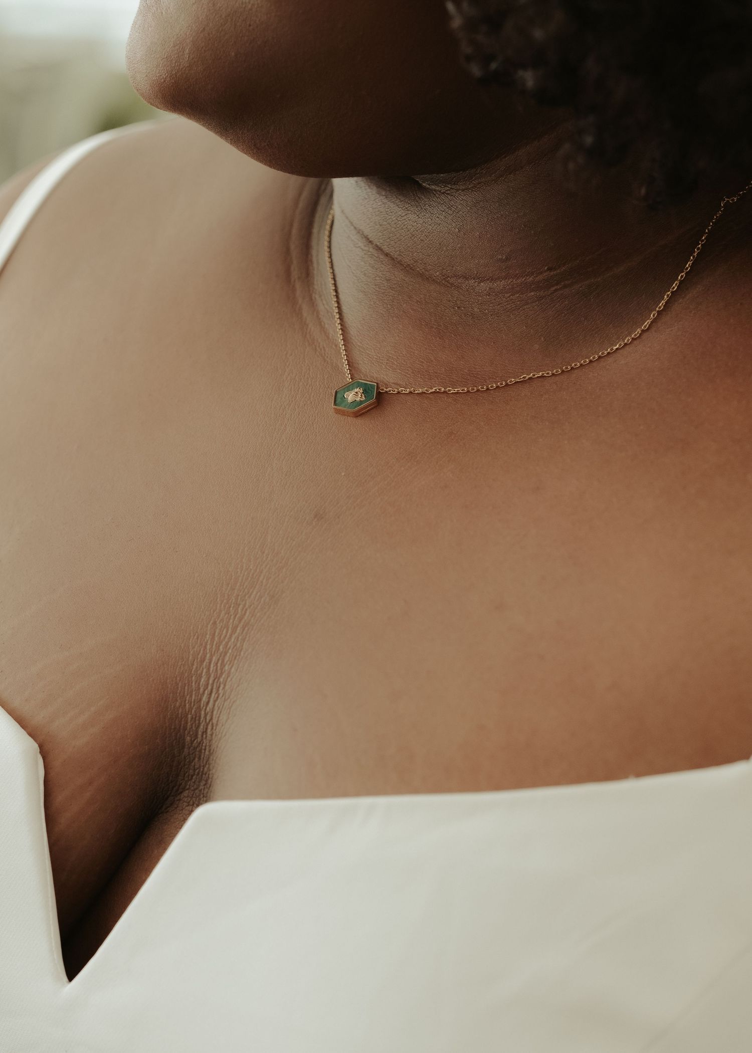 Central Virginia black bride photographed in detail close-up of green necklace in dress with low neckline by Maine Wedding Photographer
