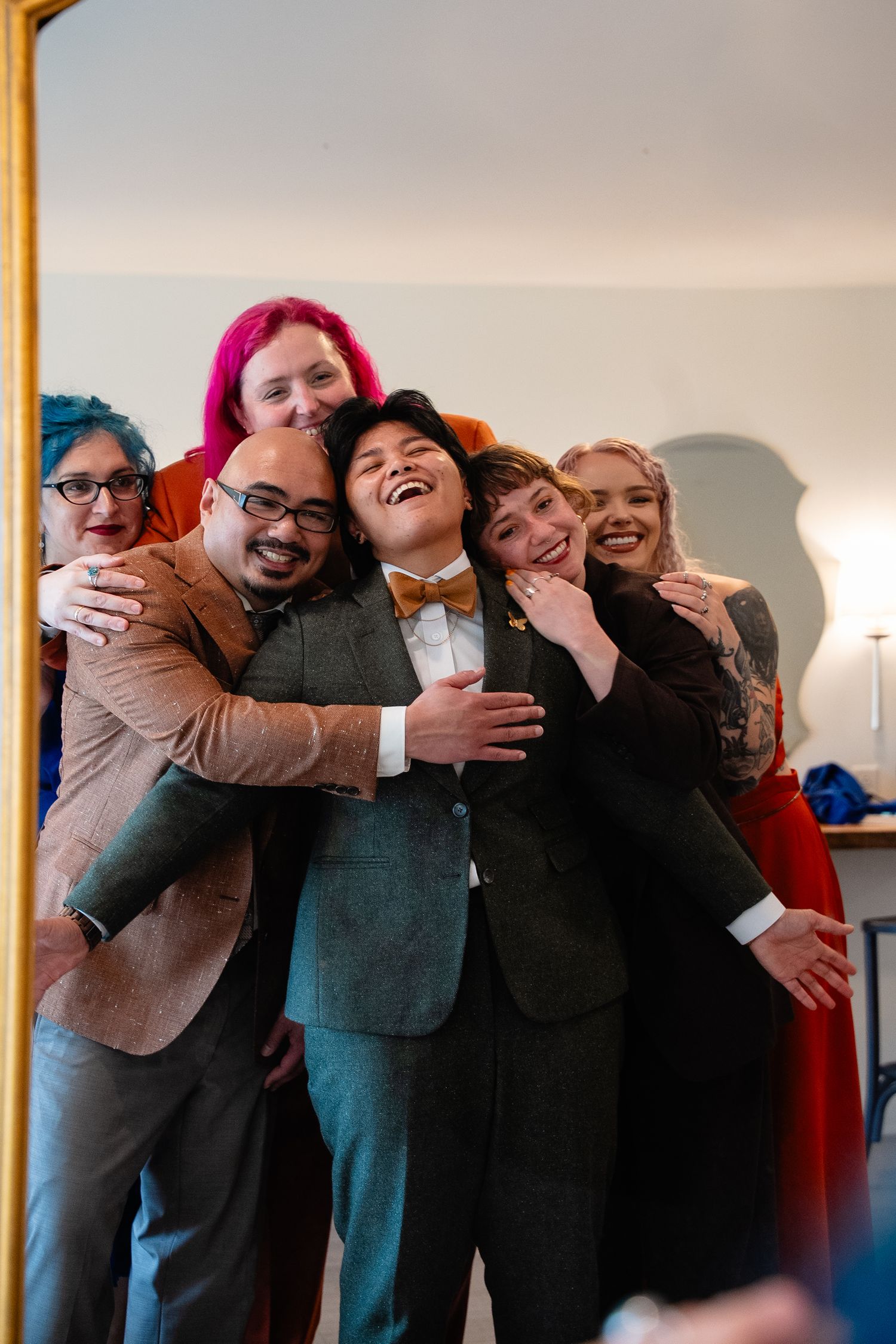 A lesbian bride is embraced by her wedding party after getting ready for her first look at Valley Road Vineyards in the Shenandoah Valley