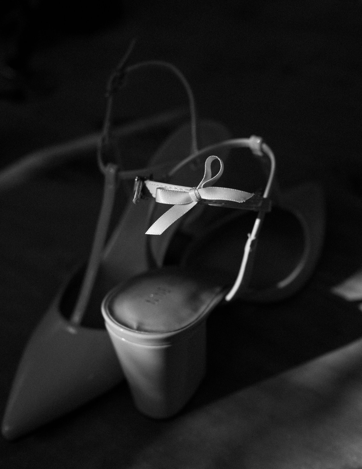Close-up detail of bow on central virginia bride's heels in black & white during lgbtq wedding by Maine Wedding Documentary Photographer