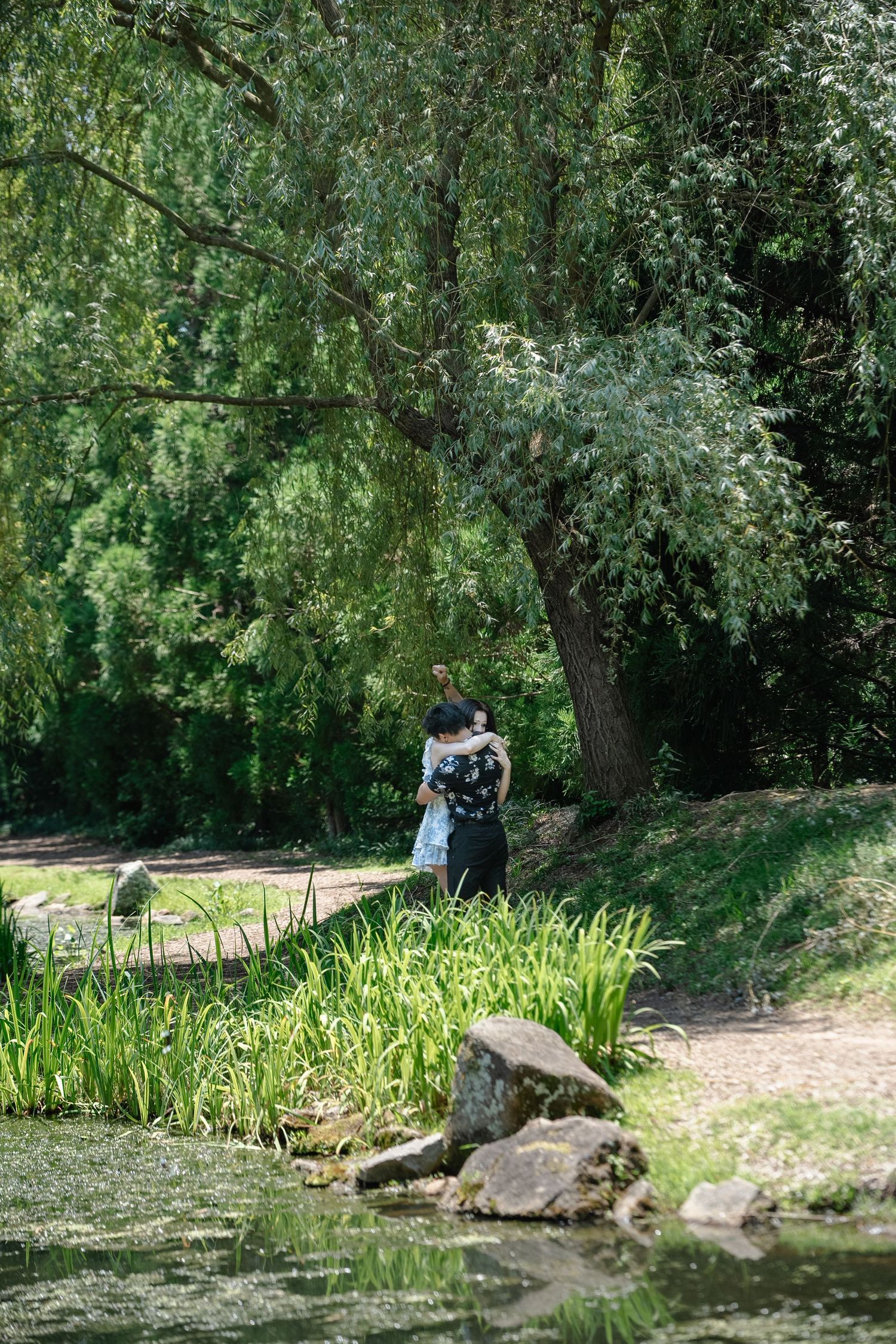 Surprise engagement spring photo session at Maymont Park in the Japanese Gardens with photographer capturing an intimate moment