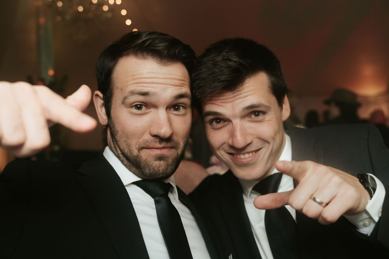 Two wedding guests smile and point at the camera during the dance party of a Mankin Mansion wedding outside Richmond, Virginia