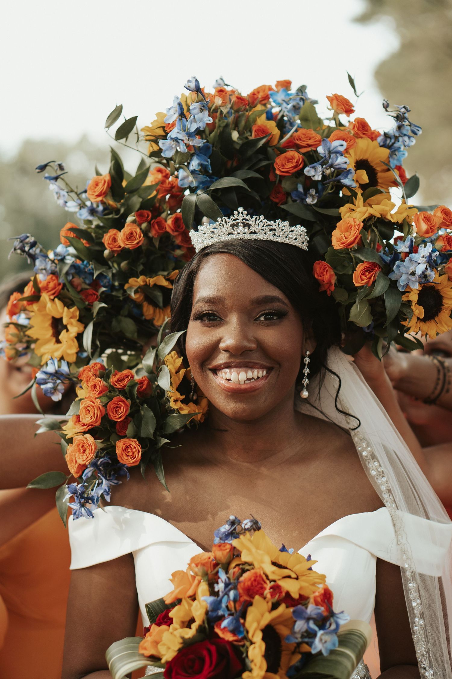 A Tidewater Virginia bride beams a smile while her bridesmaid's wreath her head in flowers