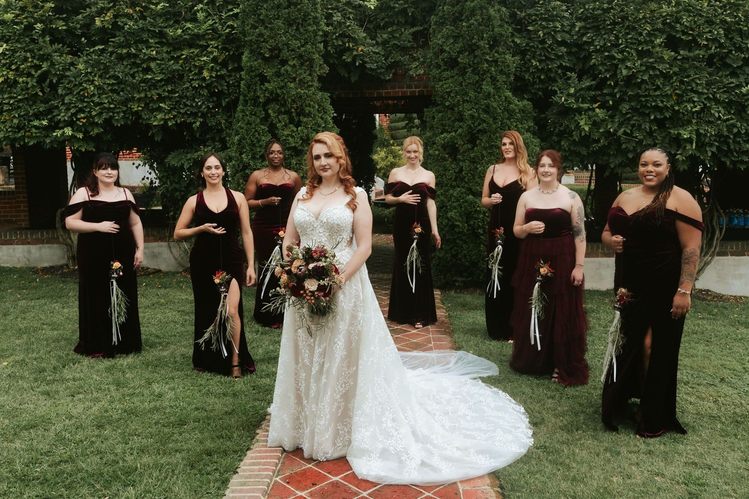 A bride is flanked by her bridesmaids in maroon dresses for a portrait before the ceremony at Mankin Mansion outside of Richmond Virginia