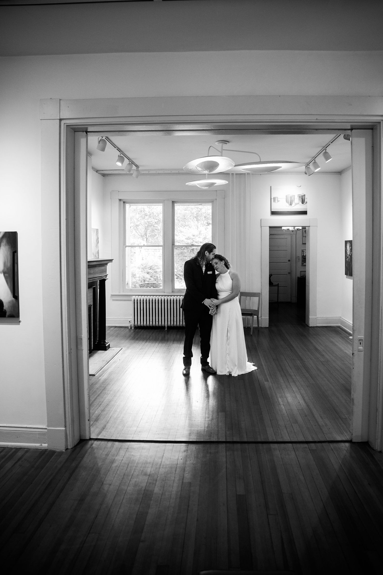Richmond virginia bride in a white dress has a quiet moment with her fiance in a suit during their first look in a Church Hill art gallery.