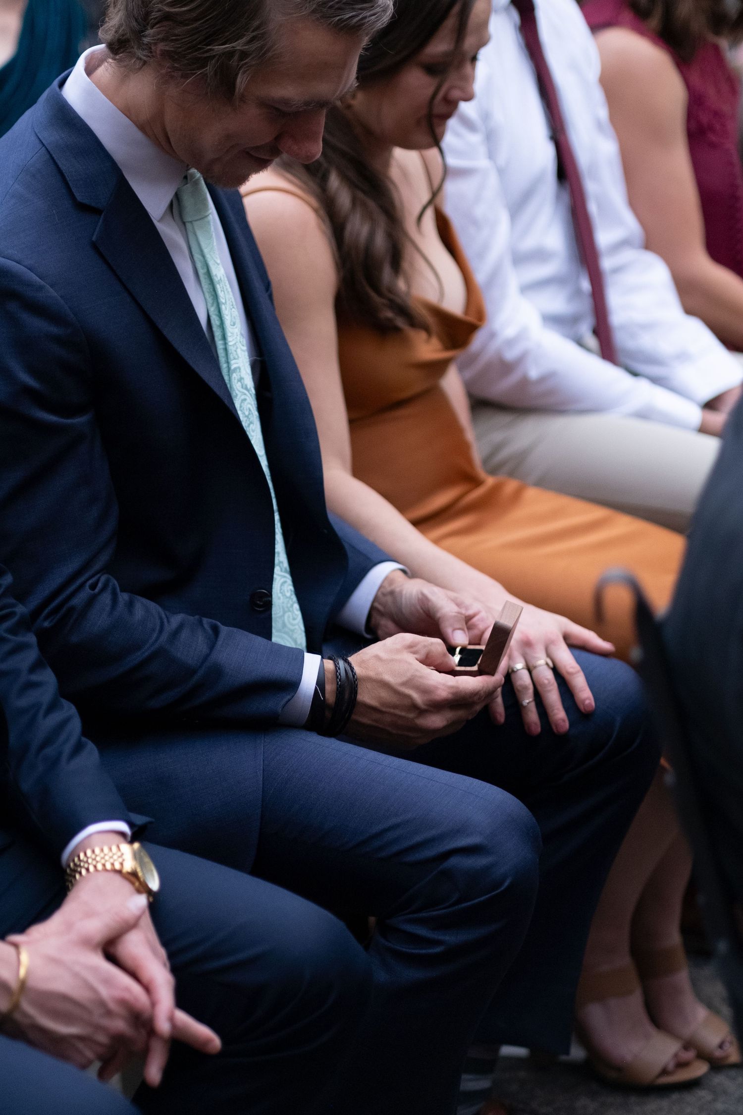 A wedding guest holds wedding rings with intention during a hand warming at a ceremony out side Richmond Virginia at Mill at Fine Creek
