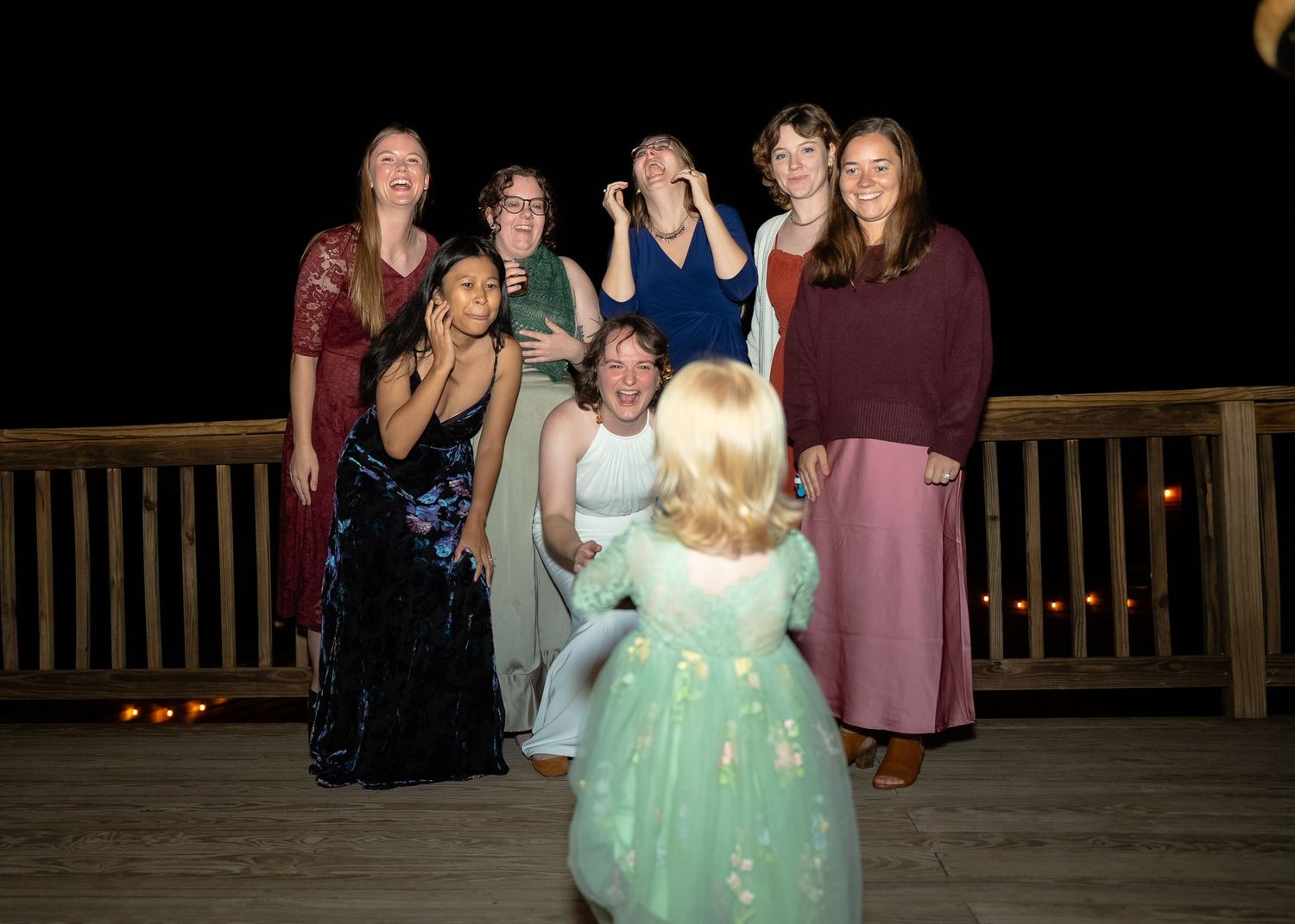 Queer bride's wedding guests react to one of their daughters surprising them during photos at Valley Road Vineyards in Shenandoah Virginia