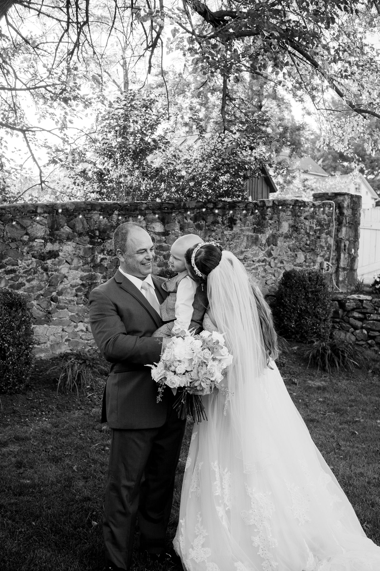 Groom holds his baby with his bride just after their wedding ceremony in Northern Virginia