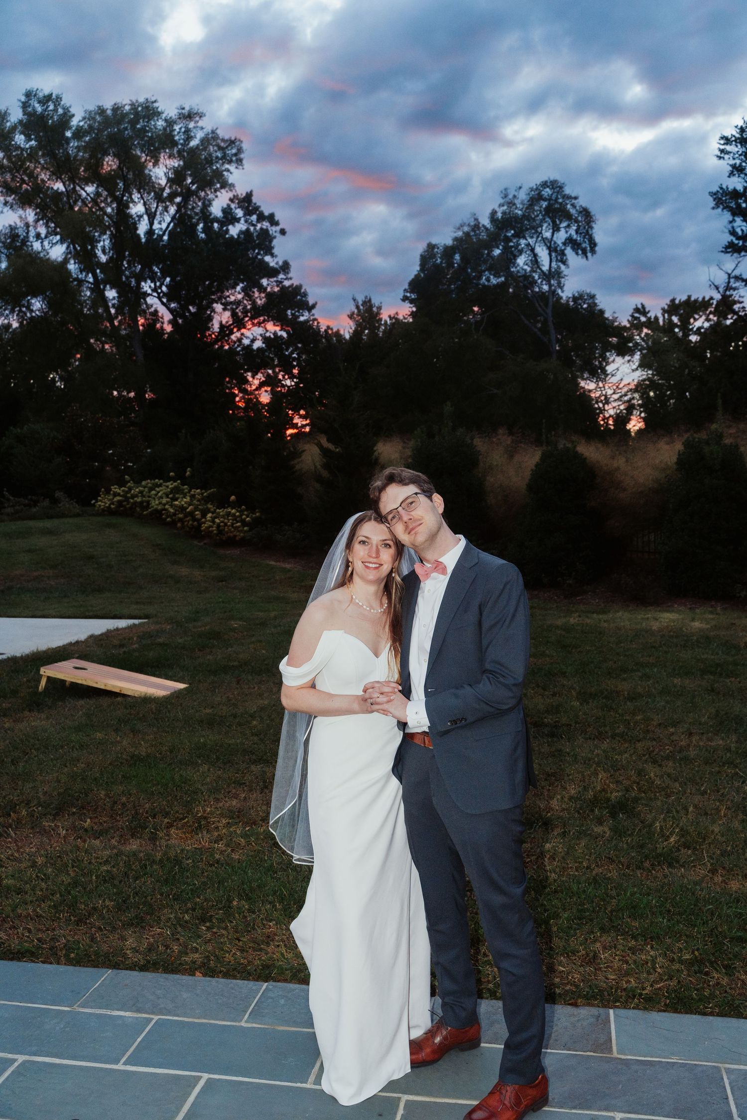 Richmond Virginia bride and groom stand together in front of an exquisite pink and purple overcast sunset