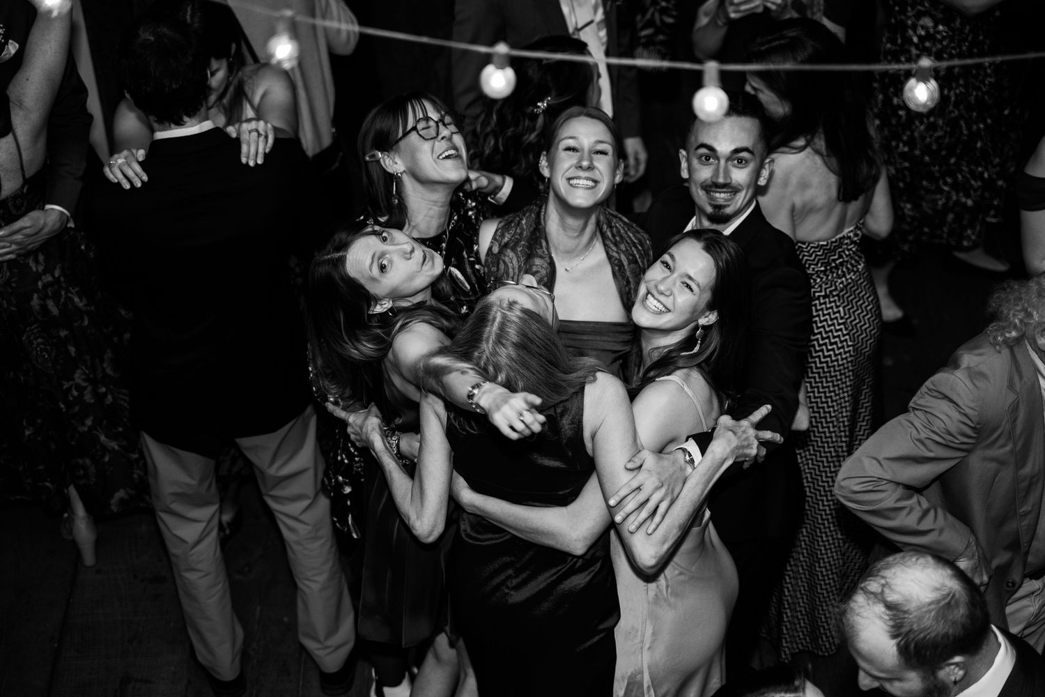 Several wedding guests turn and smile at the camera while on the dancefloor of a wedding in Northern Virginia