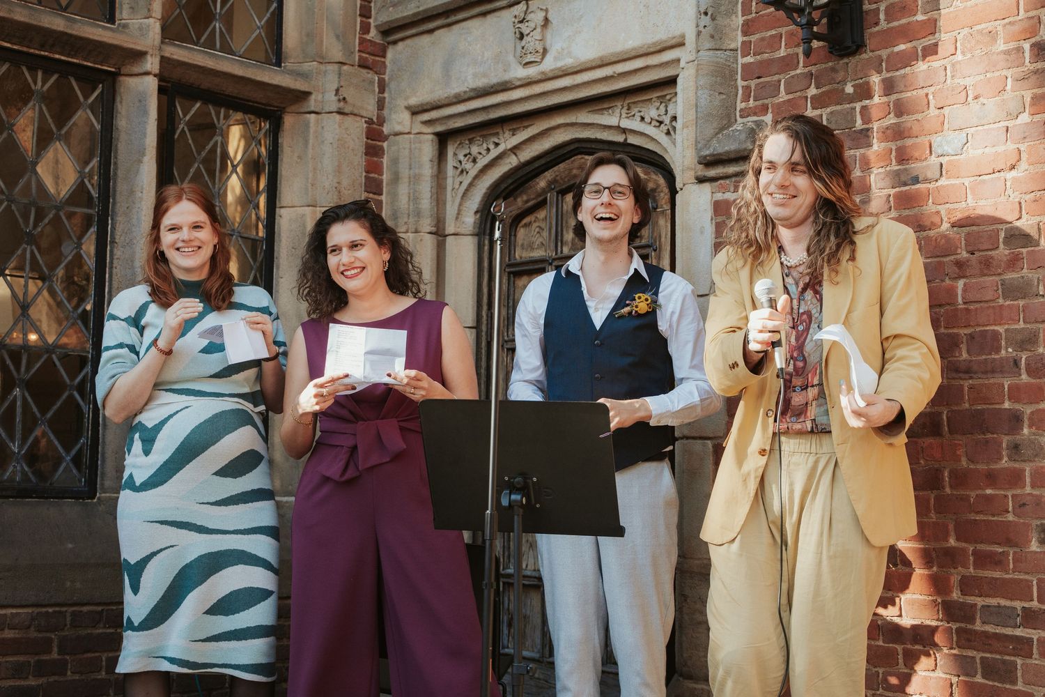 Four wedding guests perform a toast and original song for the LGBTQ bride of a wedding in the garden of The Branch Museum