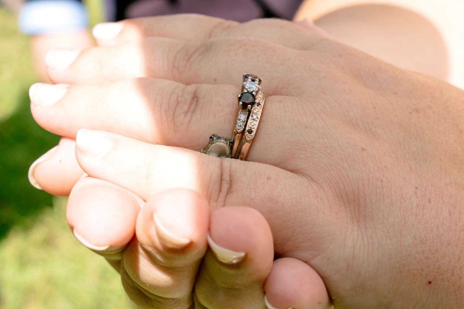 Close-up detail wedding photo of hands with engagement and wedding rings in documentary-style photo session