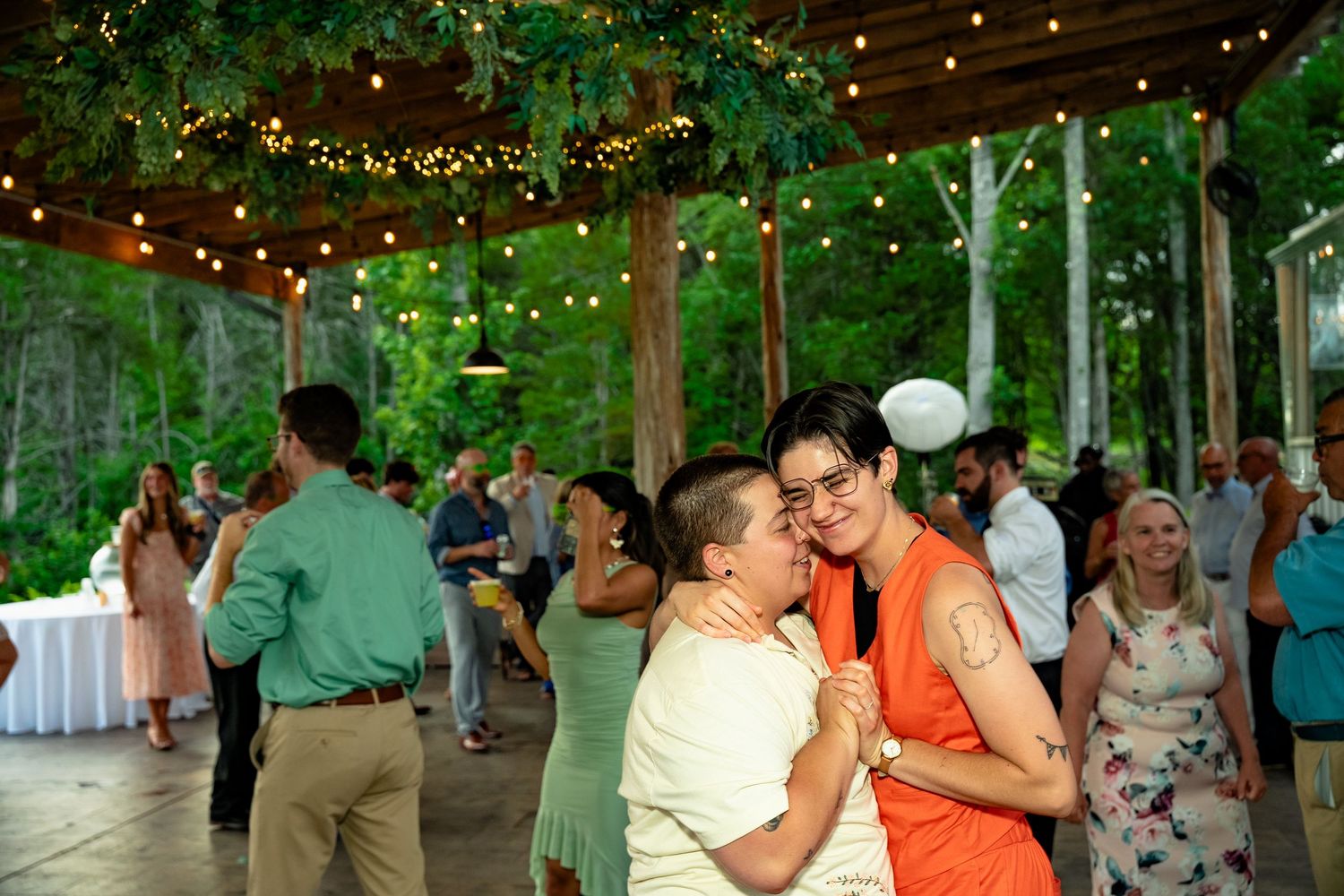 A couple of wedding guests dance under the pavilion during a wedding at Avonlea Farms