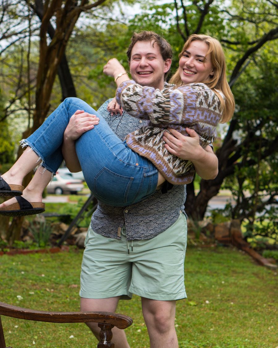 Portland, ME queer wedding and event photographer Dan Bowler poses while holding his non-binary partner