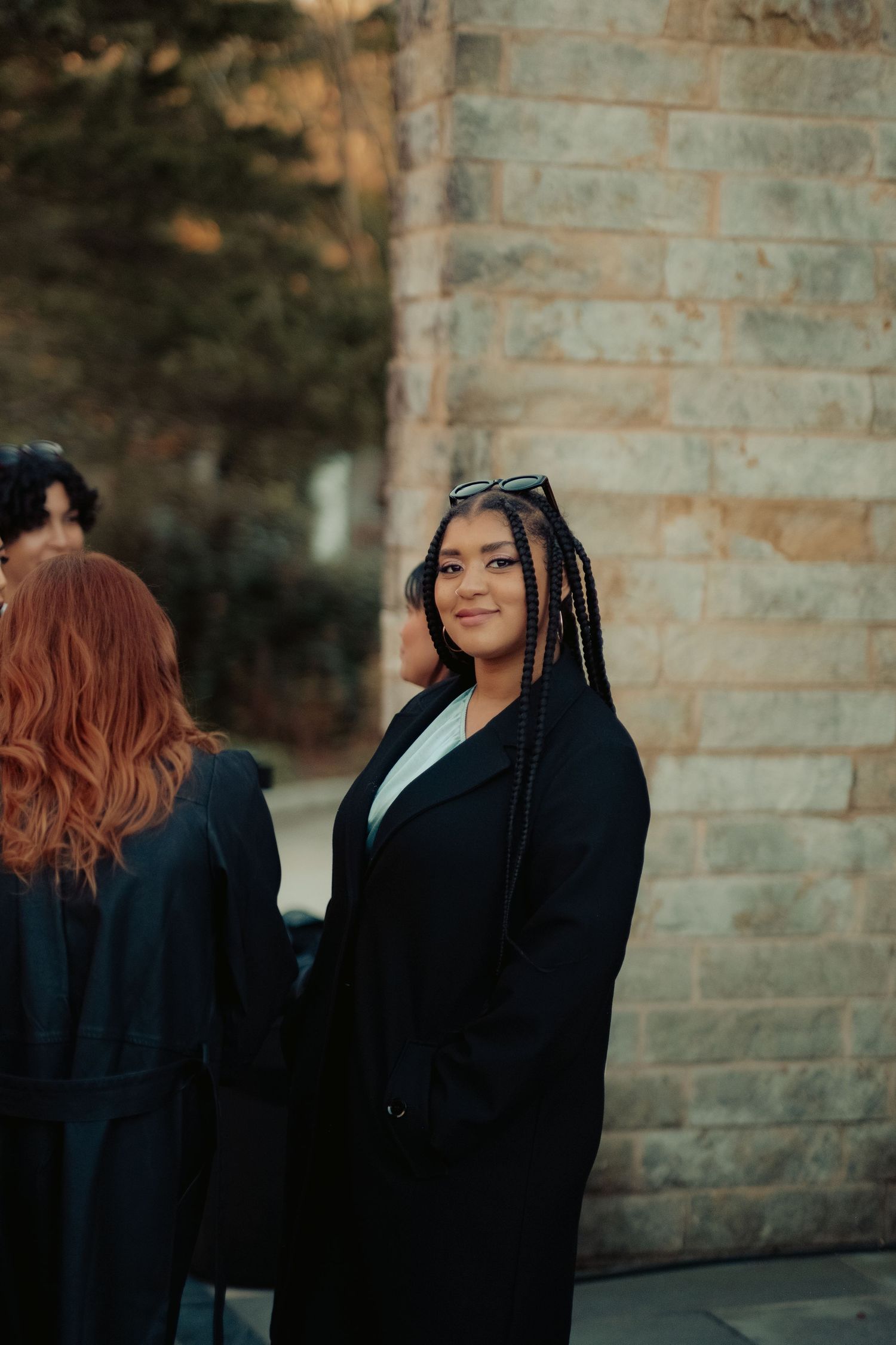 Wedding guest turns to the camera with a subtle smile during a cocktail hour at a queer wedding in Marlyand
