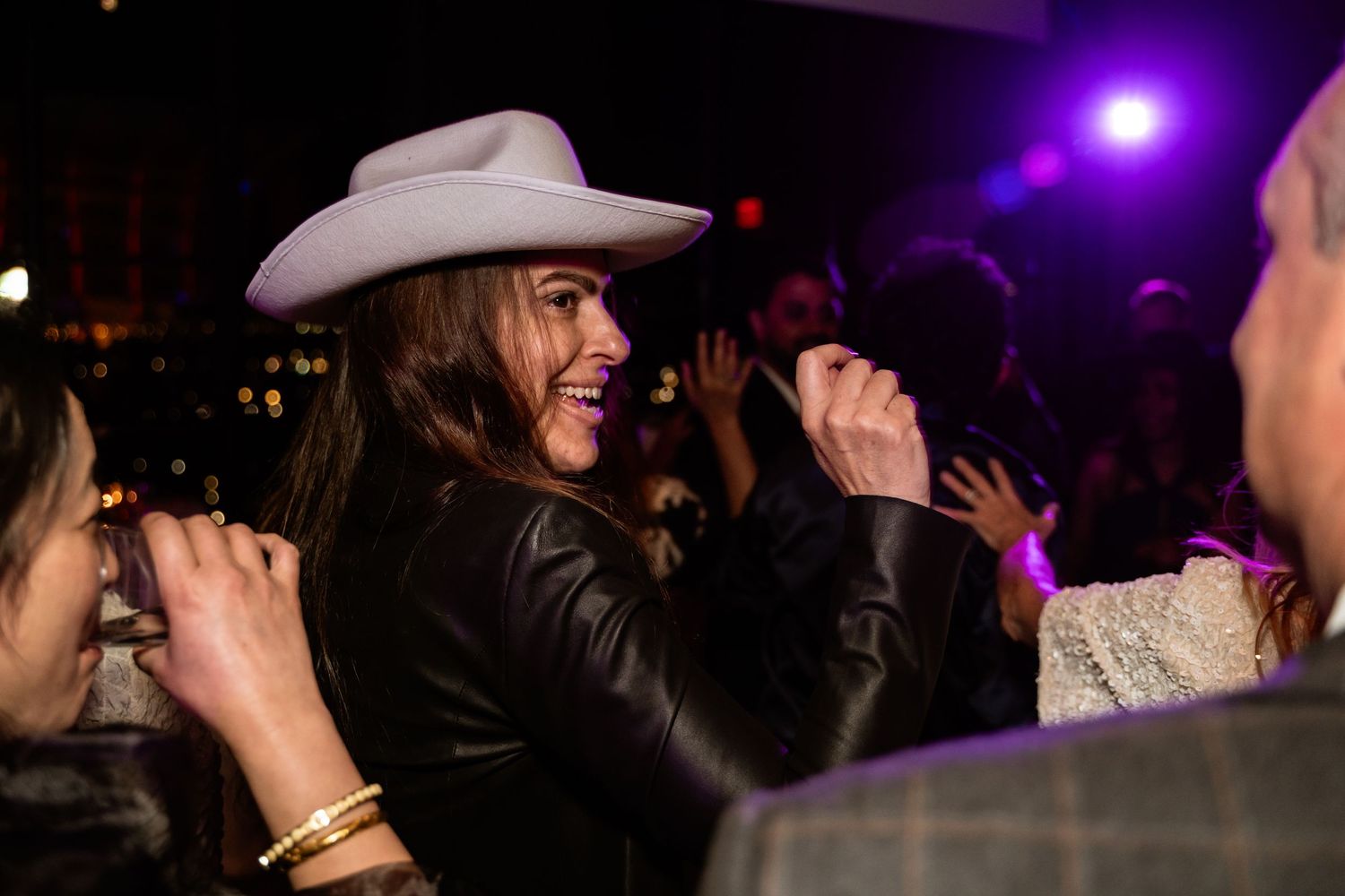 A wedding guest in a cowboy hat grins on the dancefloor during a wedding at the Hotel Washington in Washington DC