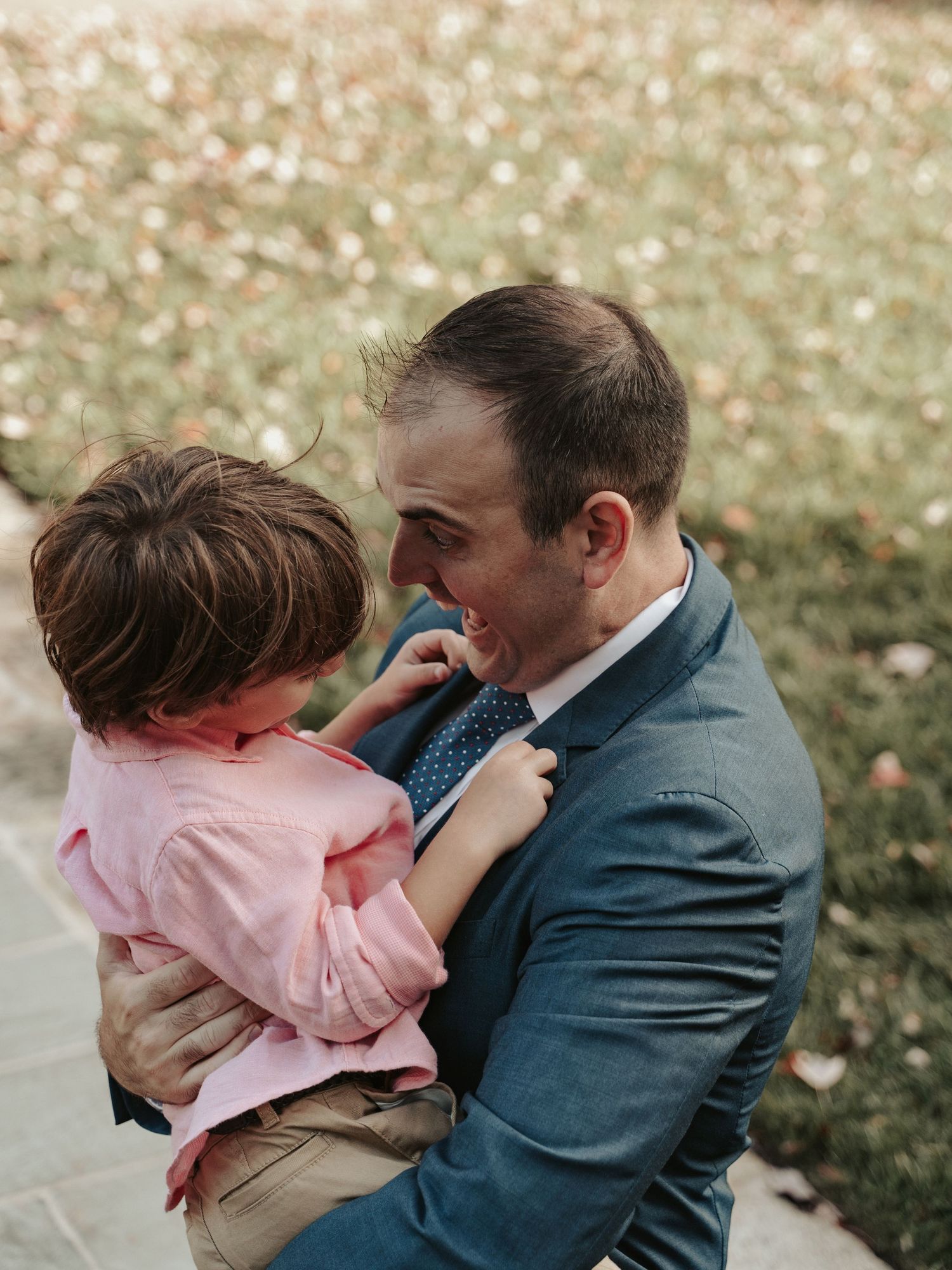 Wedding guest makes his son to laugh while waiting for the ceremony of a gay wedding to start at Maymont Gardens in Richmond Virginia