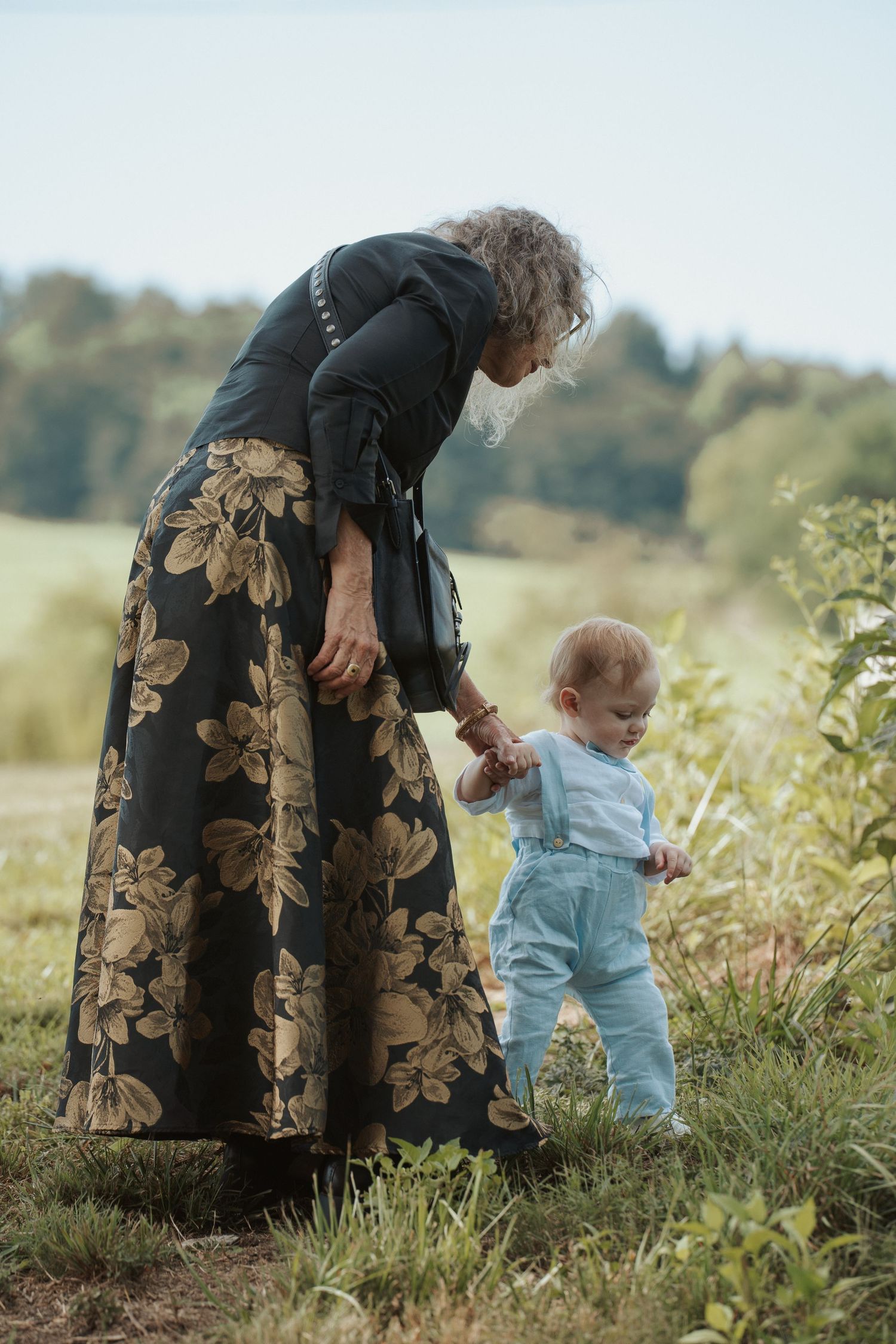 Toddler explores a creekbed alongside his grandmother while they wait for the wedding ceremony of his parents in the Blue Ridge Mountains