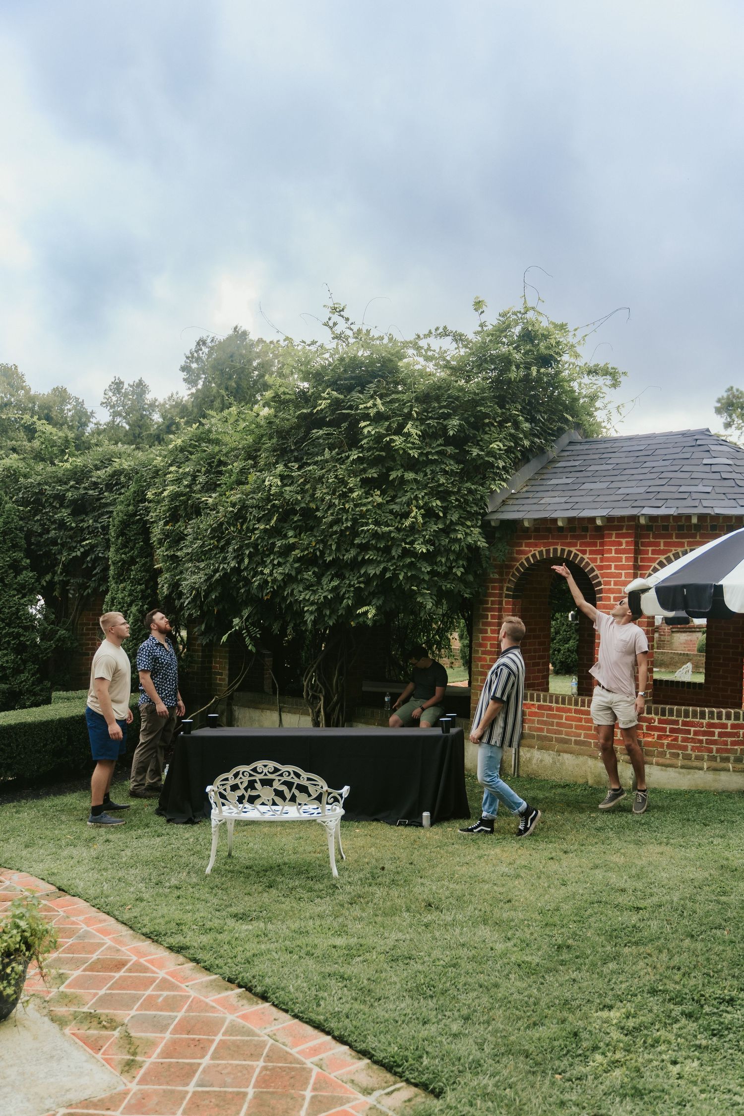 A groom and three groomsmen play beer die in the hours they have free before getting ready for the wedding ceremony at Mankin Mansion