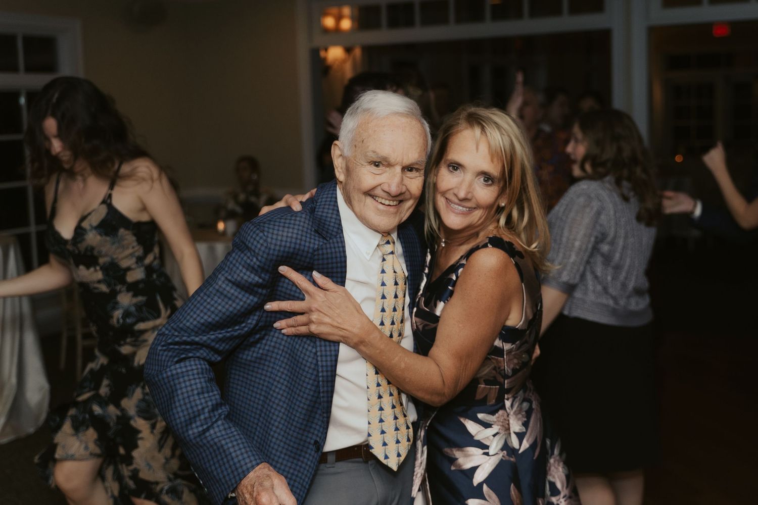 Wedding guest poses with her father on the dancefloor during a reception at Mill at Fine Creek outside Richmond Virginia