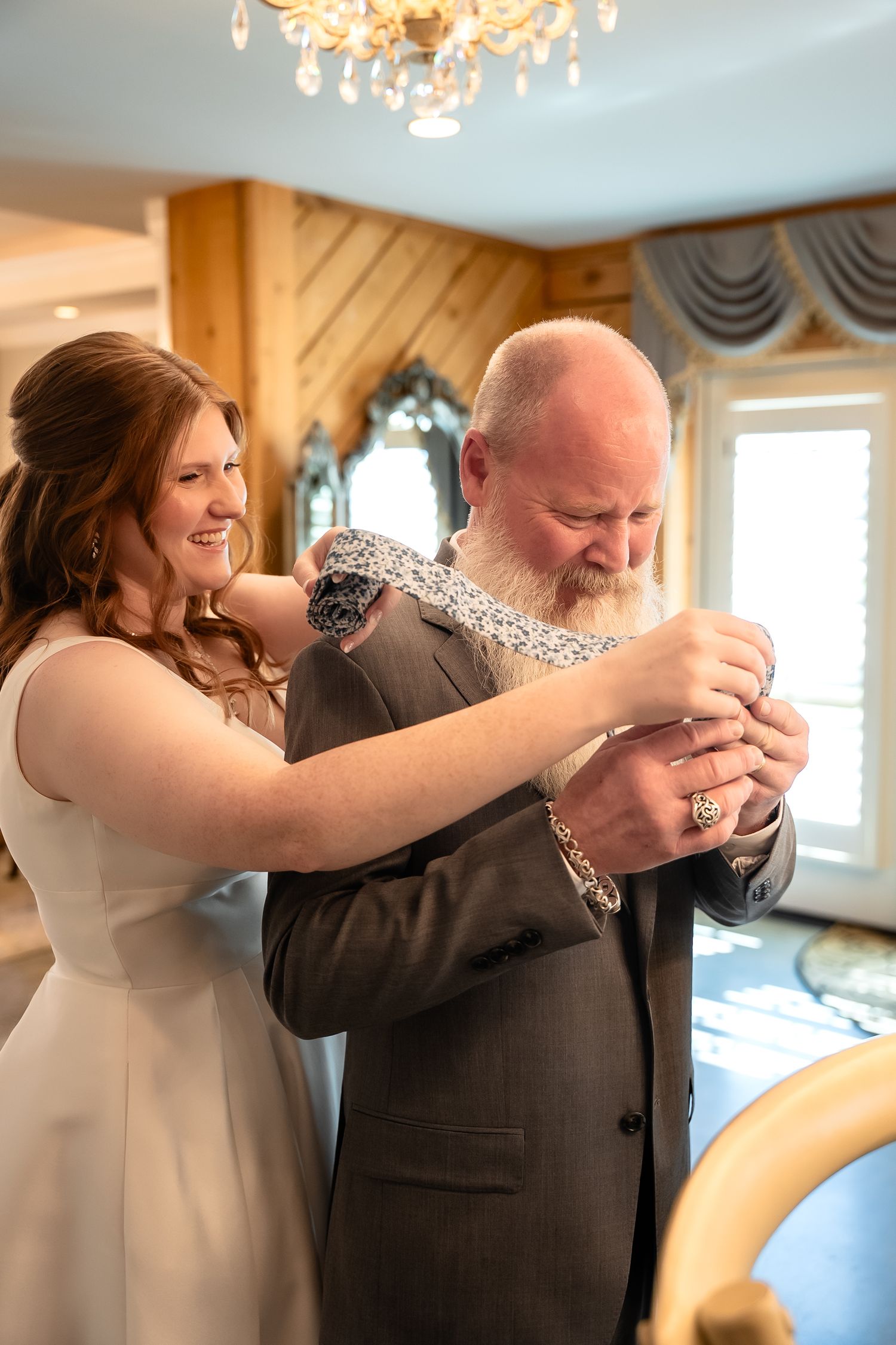 Father of the bride tears up as she shows him a tie with picture of them stitched into the back before her wedding in the Shenandoah Valley