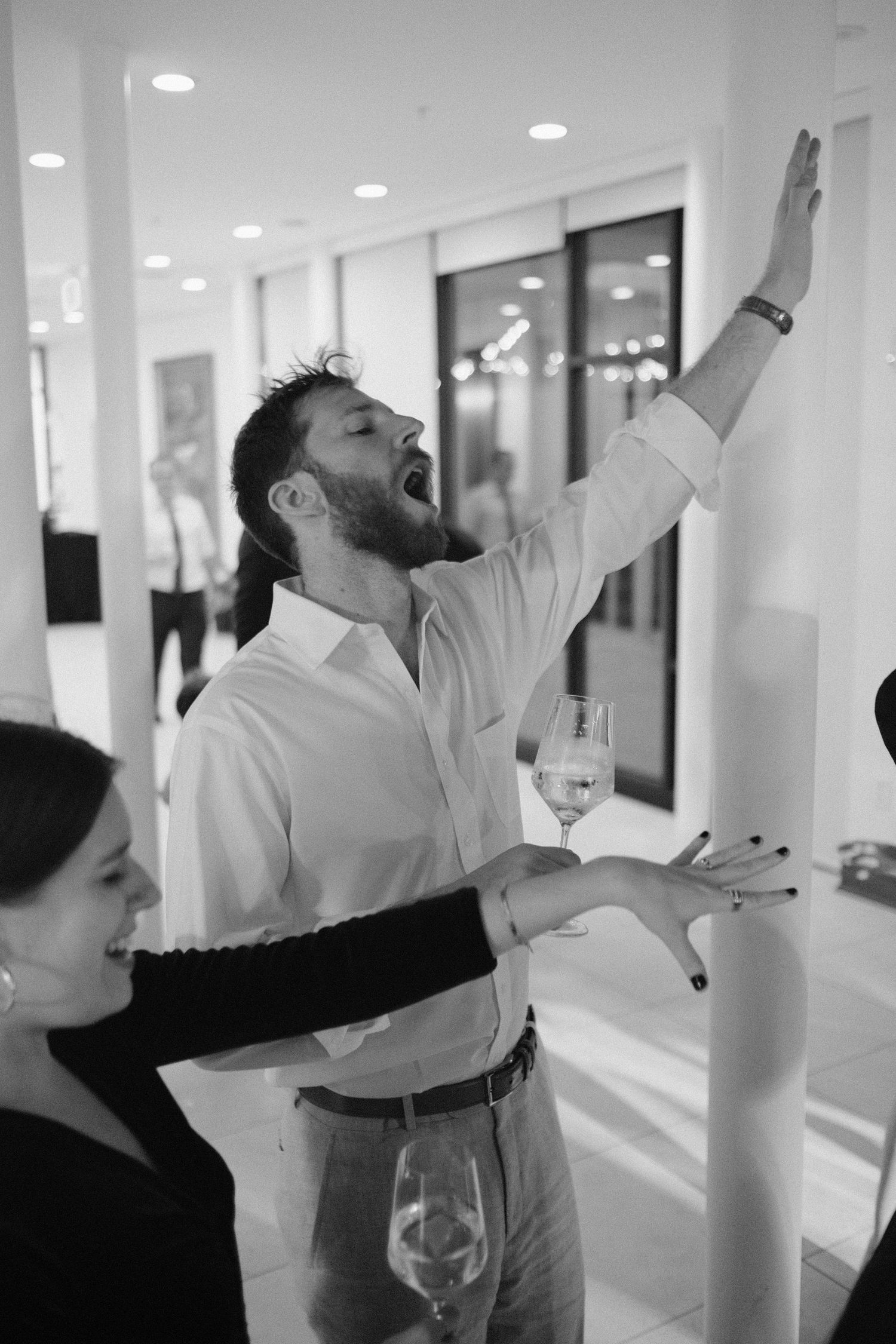 A wedding guest holds his hand up and sings during the dance party of a wedding reception at Maymont Park in Richmond, Virginia