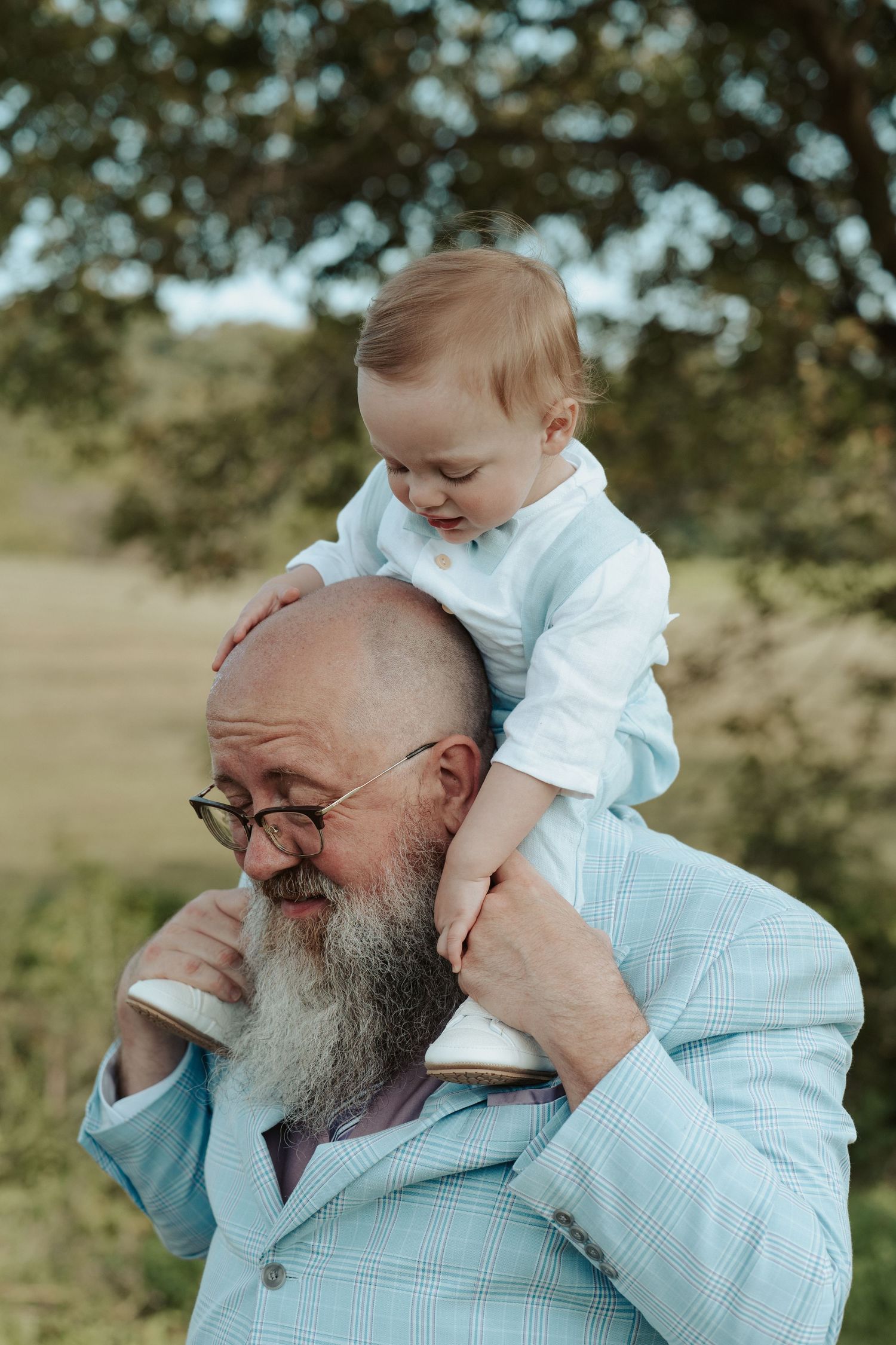 Son of the groom rides his dad's shoulders in documentary portrait photo at Central Virginia wedding
