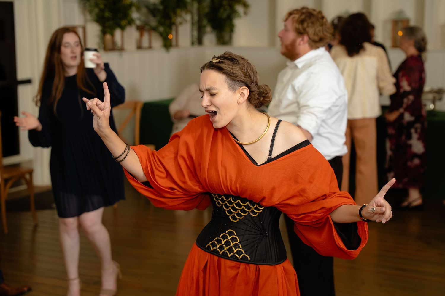 A wedding bridesmaid sings along emphatically to music on the dancefloor of a LGBTQ wedding in the Blue Ridge Mountains